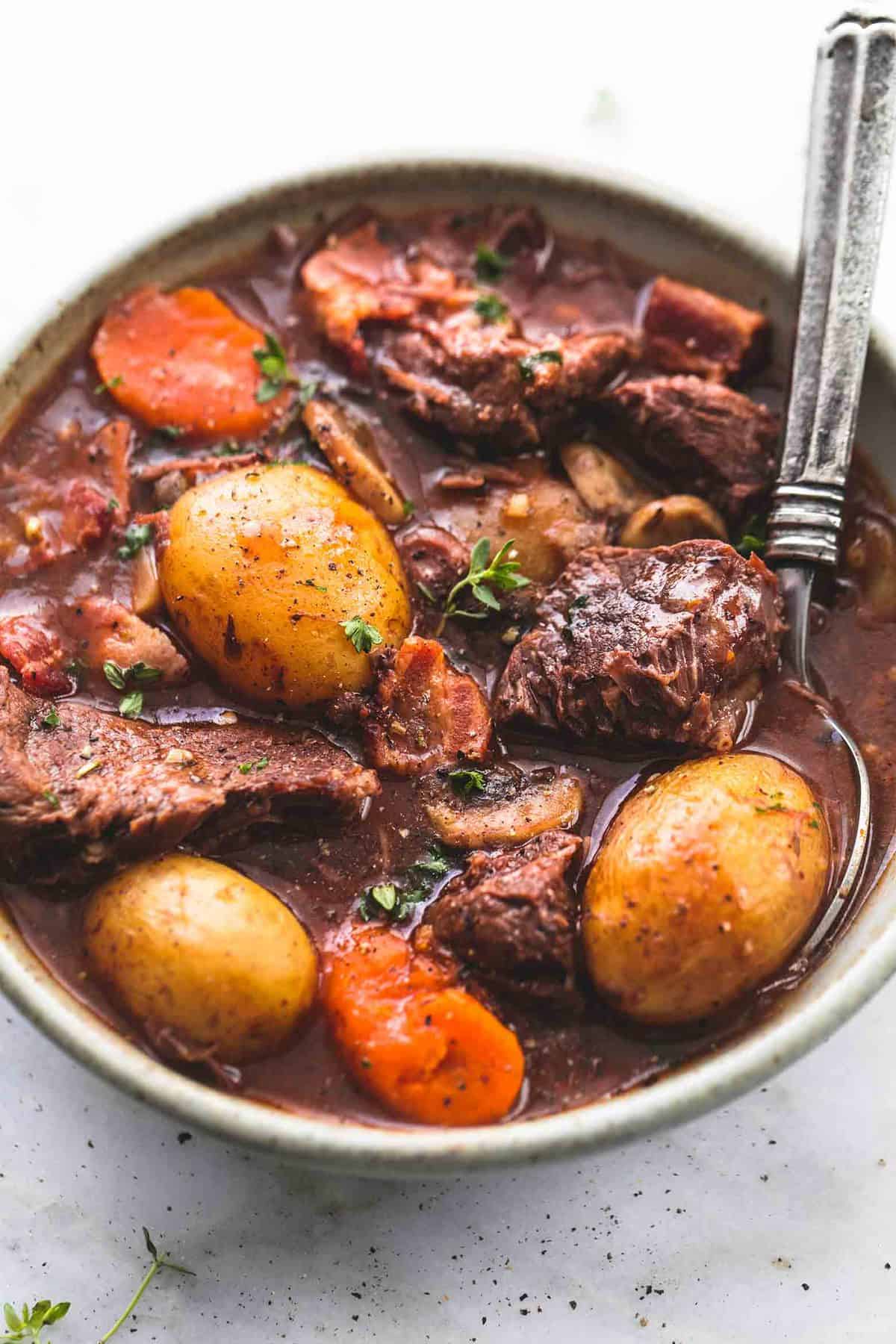 rapid pot red meat bourguignon with a spoon in a bowl.