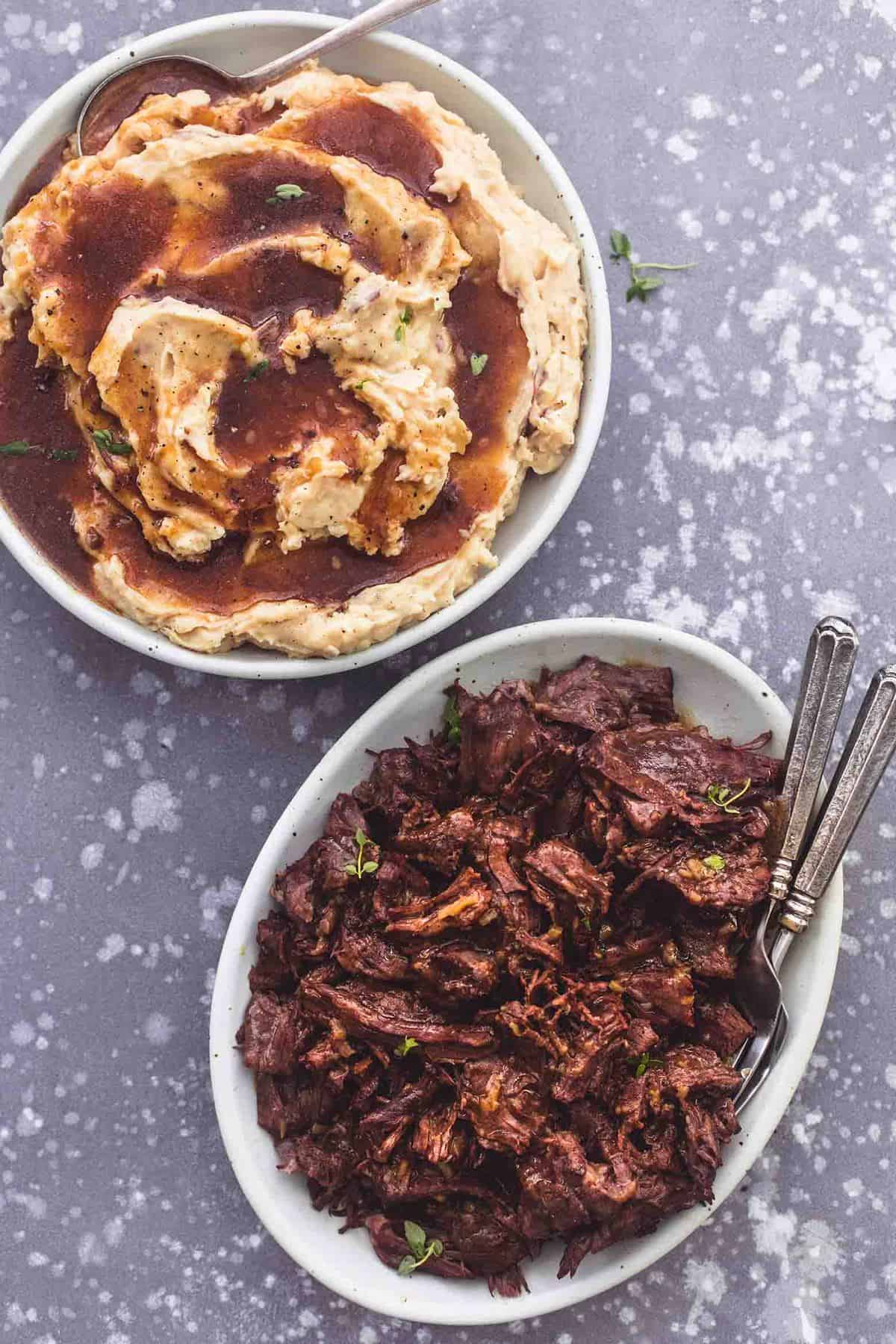 top view of a bowl of mashed potatoes and gravy with a plate of instant pot pot roast on the side.