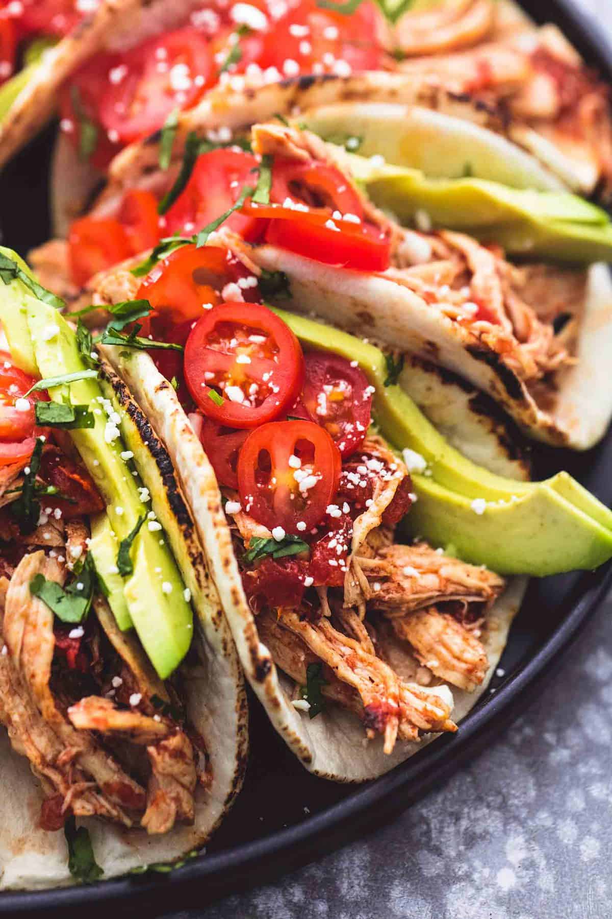 close up of instant pot shredded chicken tacos on a round platter.