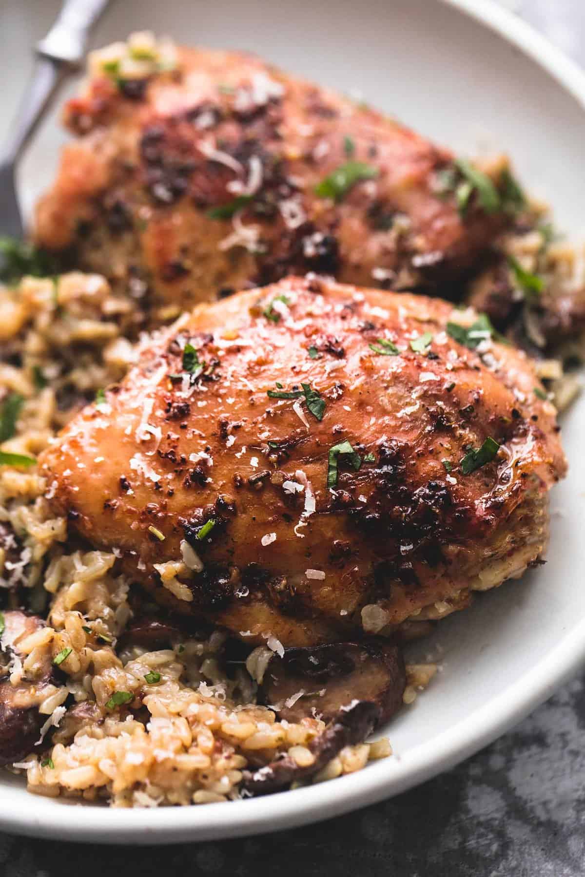 close up of instant pot parmesan chicken and mushroom rice with a fork on a plate.