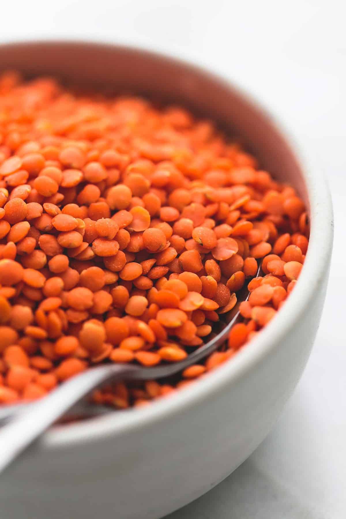 close up of lentils and a spoon in a bowl.