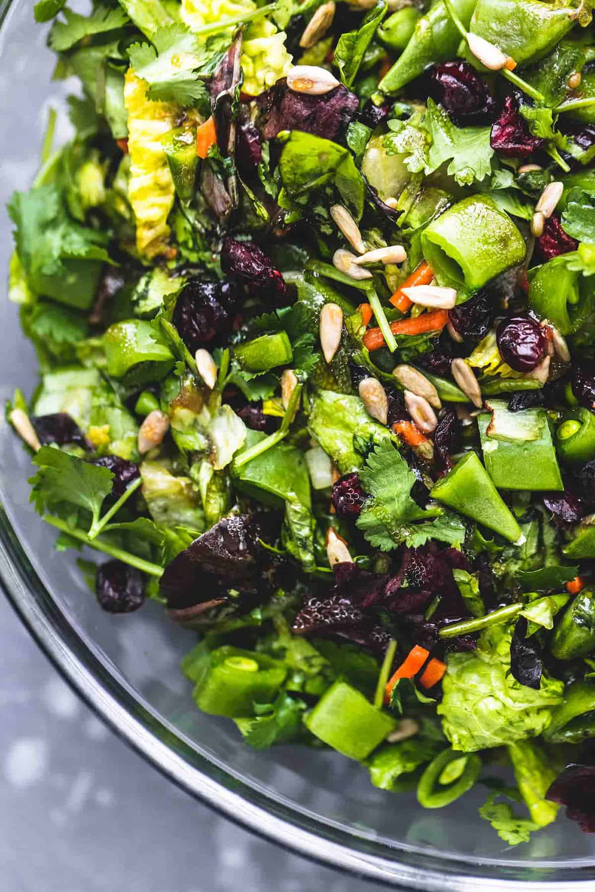 close up top view of chopped Asian salad in a glass bowl.