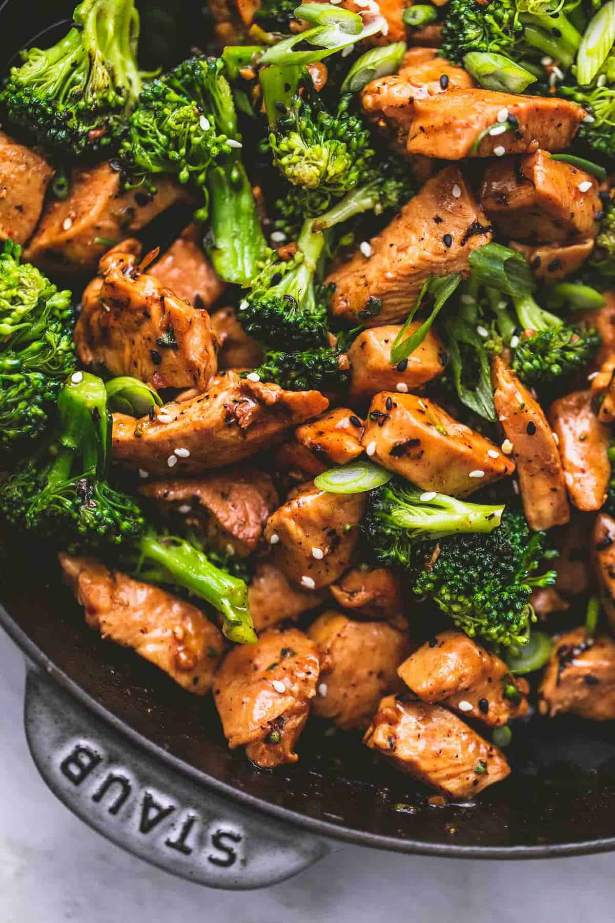 close up top view of chicken and broccoli stir fry in a pan.