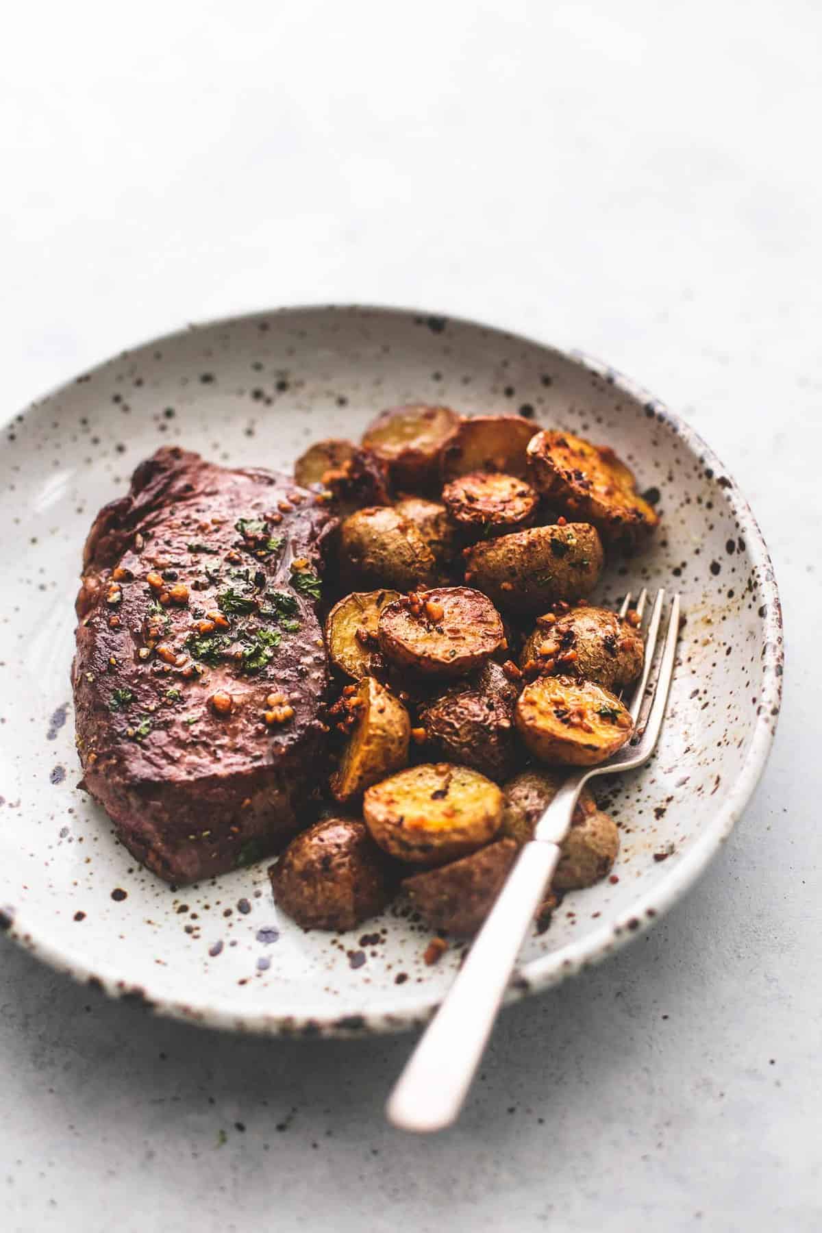 garlic butter steak and potatoes skillet with a fork on a plate.