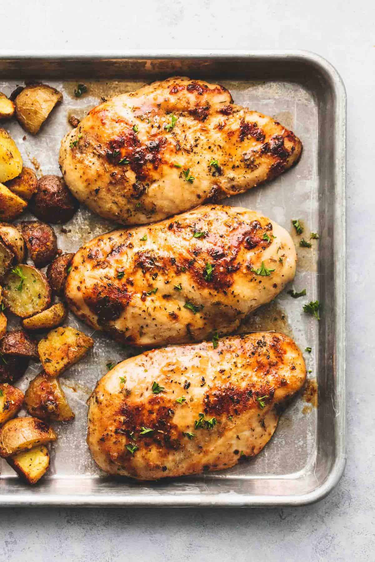 close up top view of sheet pan chicken and potatoes on a sheet pan.