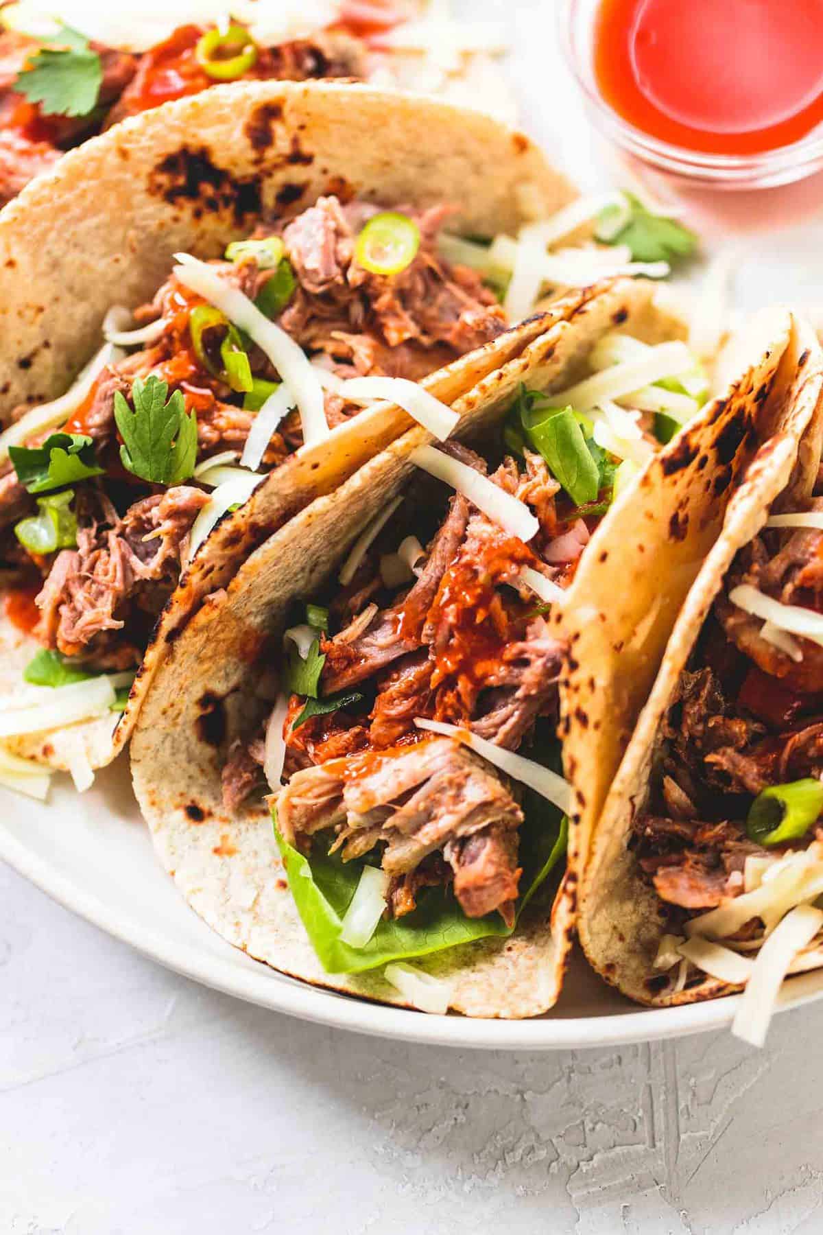 close up of slow cooker pork tacos on a plate.