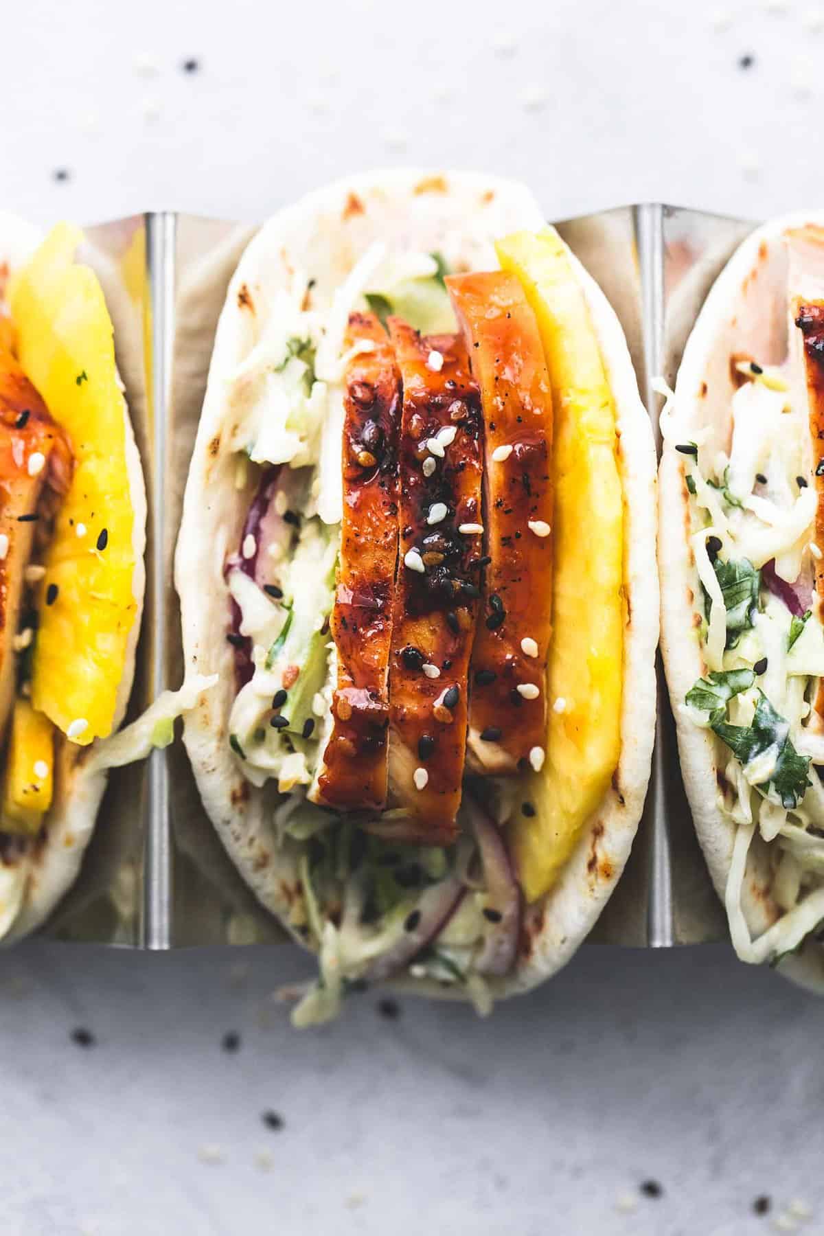 top view of a teriyaki chicken taco on a taco rack with more tacos on the side.