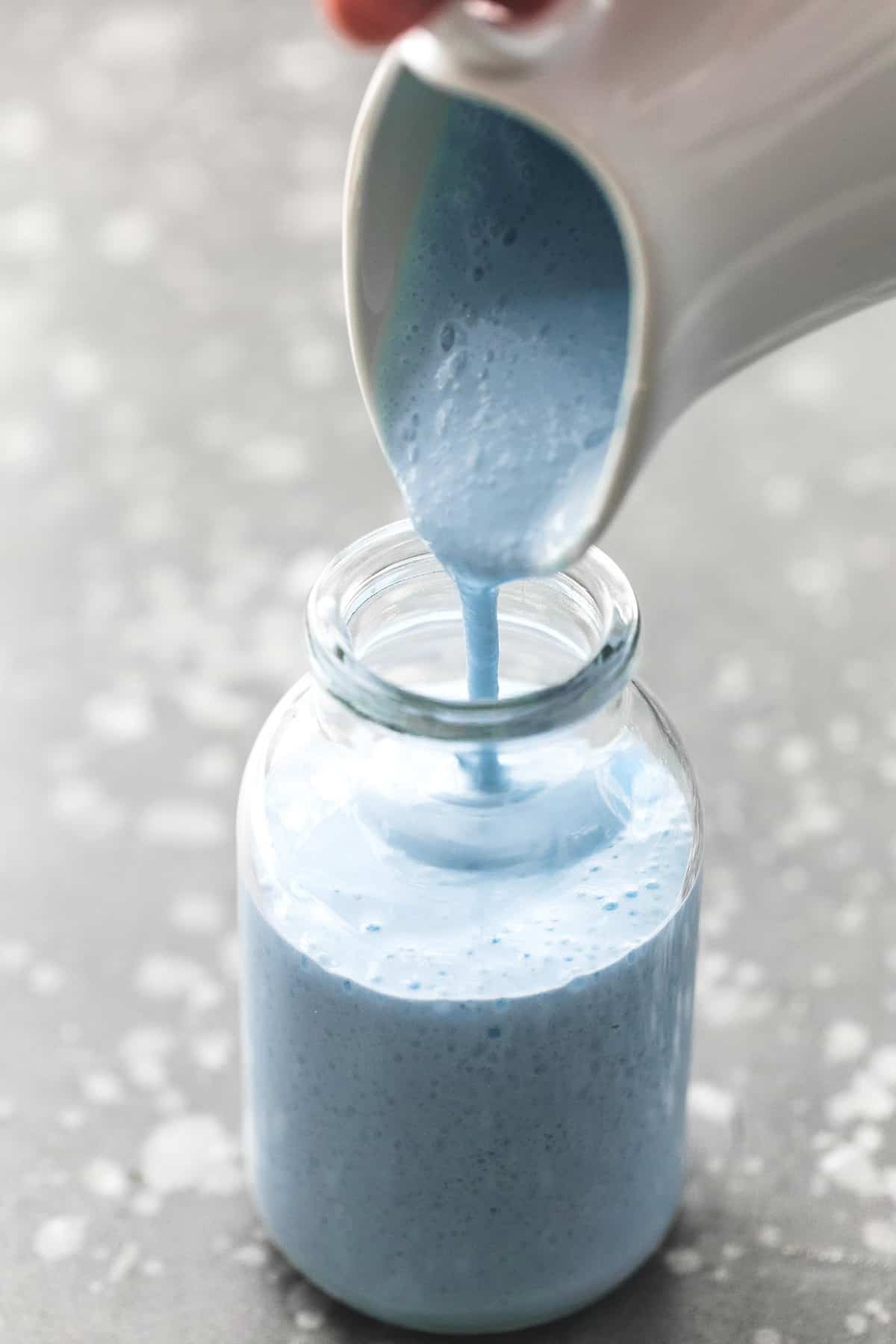 galaxy's edge blue milk (Disneyland Copycat) being poured from a white pitcher into a glass jar.