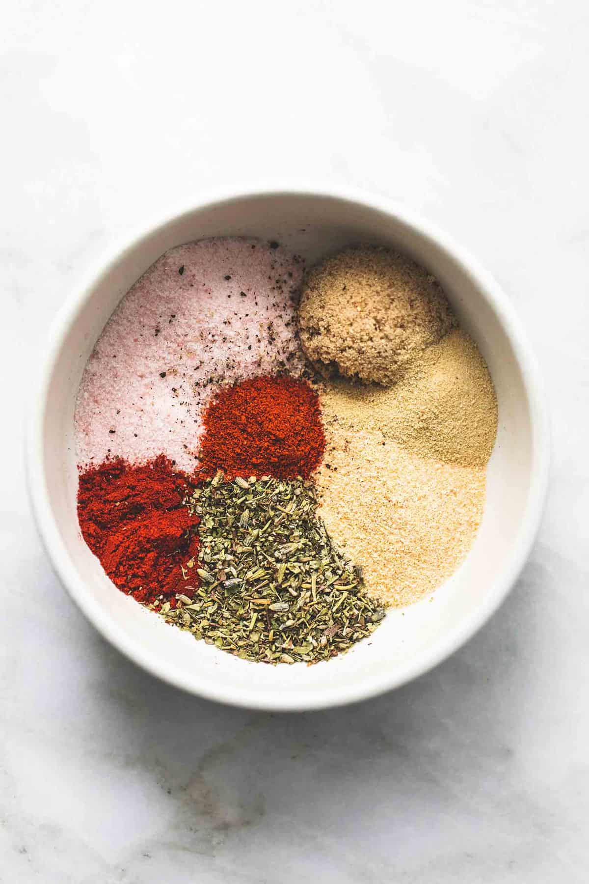 top view of grilled chicken dry rub unmixed in a bowl.