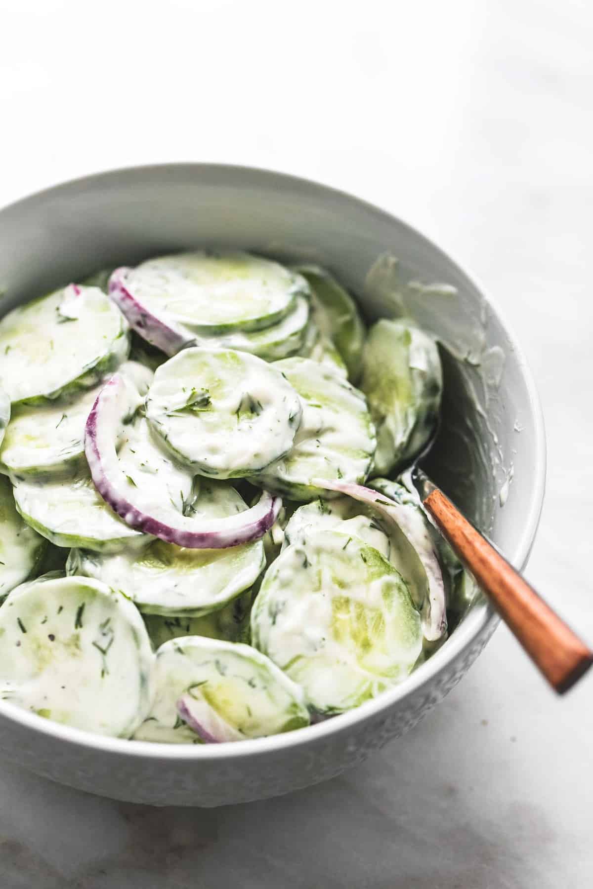 creamy cucumber salad with a fork in a bowl.