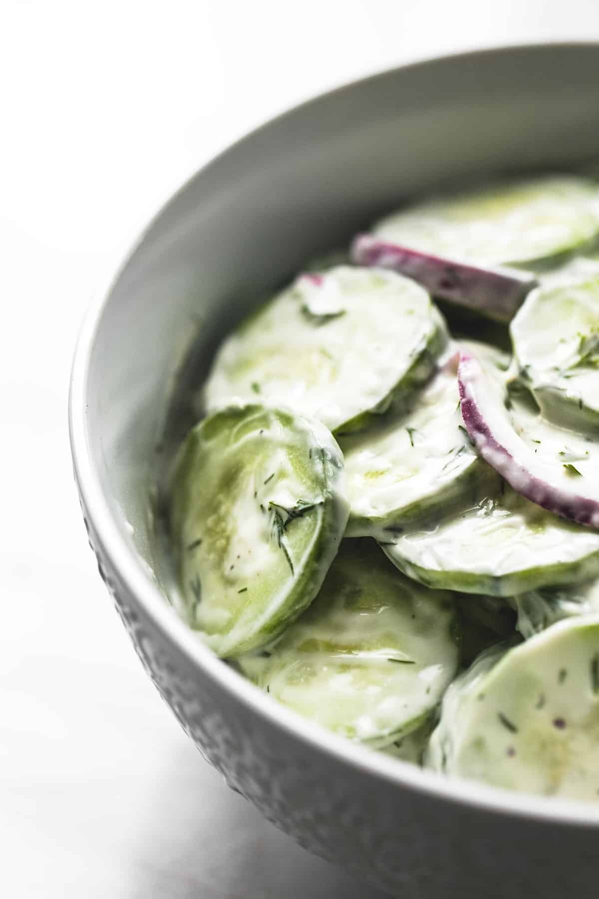 close up creamy cucumber salad in a bowl.