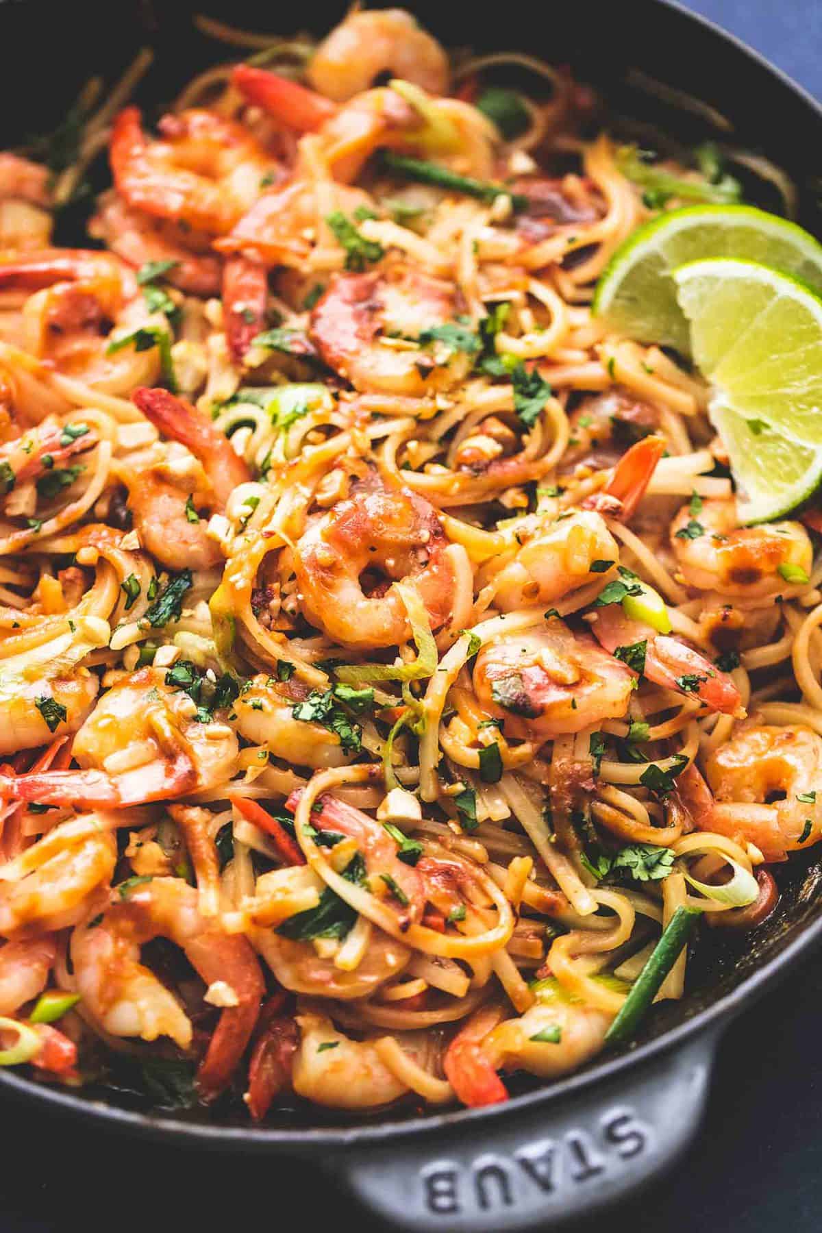 close up of shrimp pad Thai with peanut sauce in a pan.
