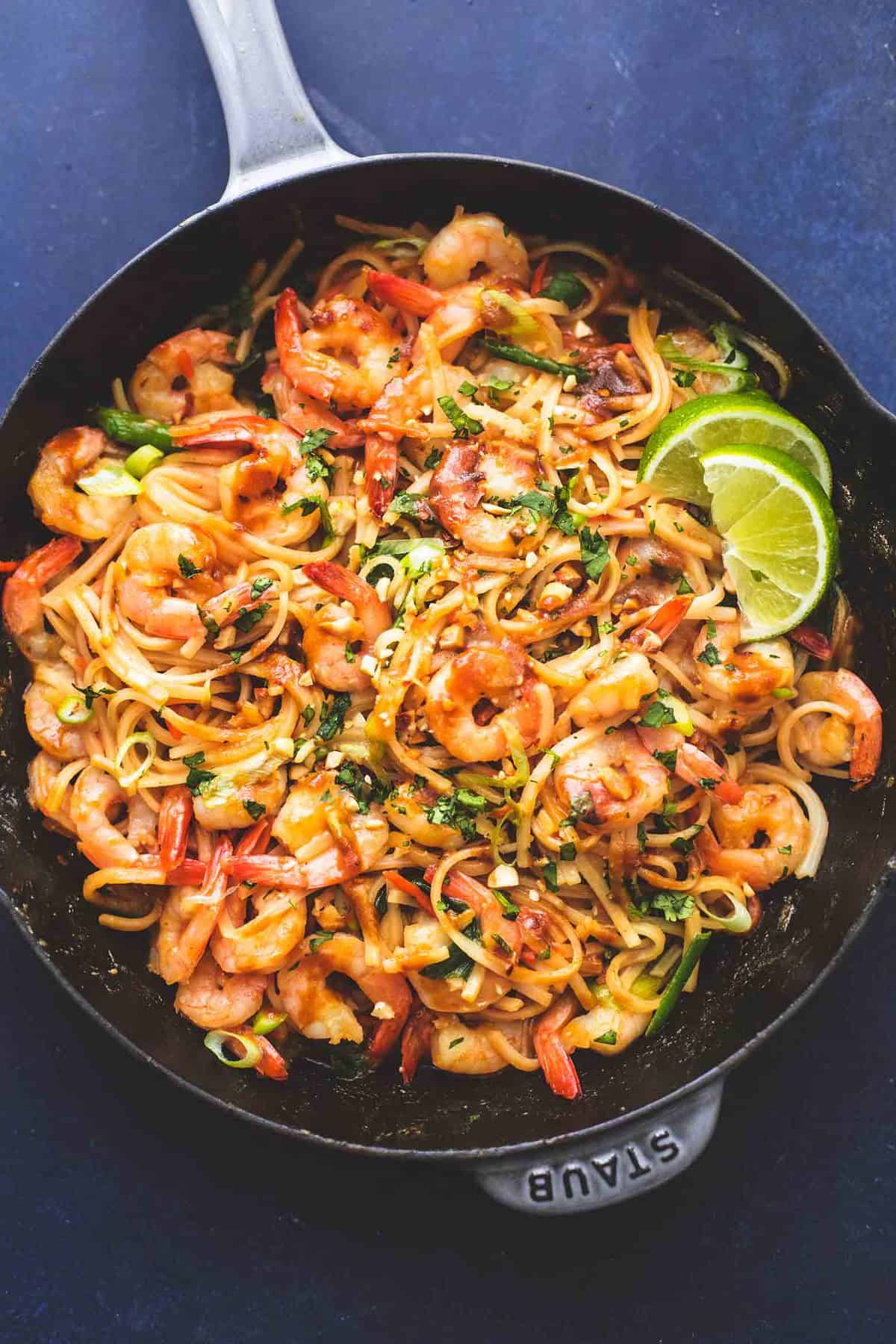 top view of shrimp pad Thai with peanut sauce in a pan.