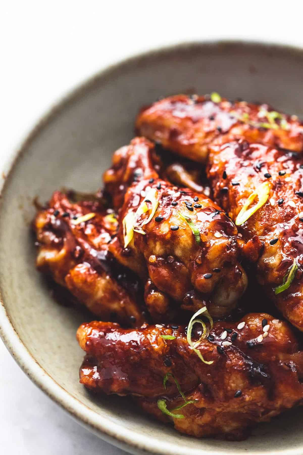 close up of spicy Korean bbq chicken wings on a plate.