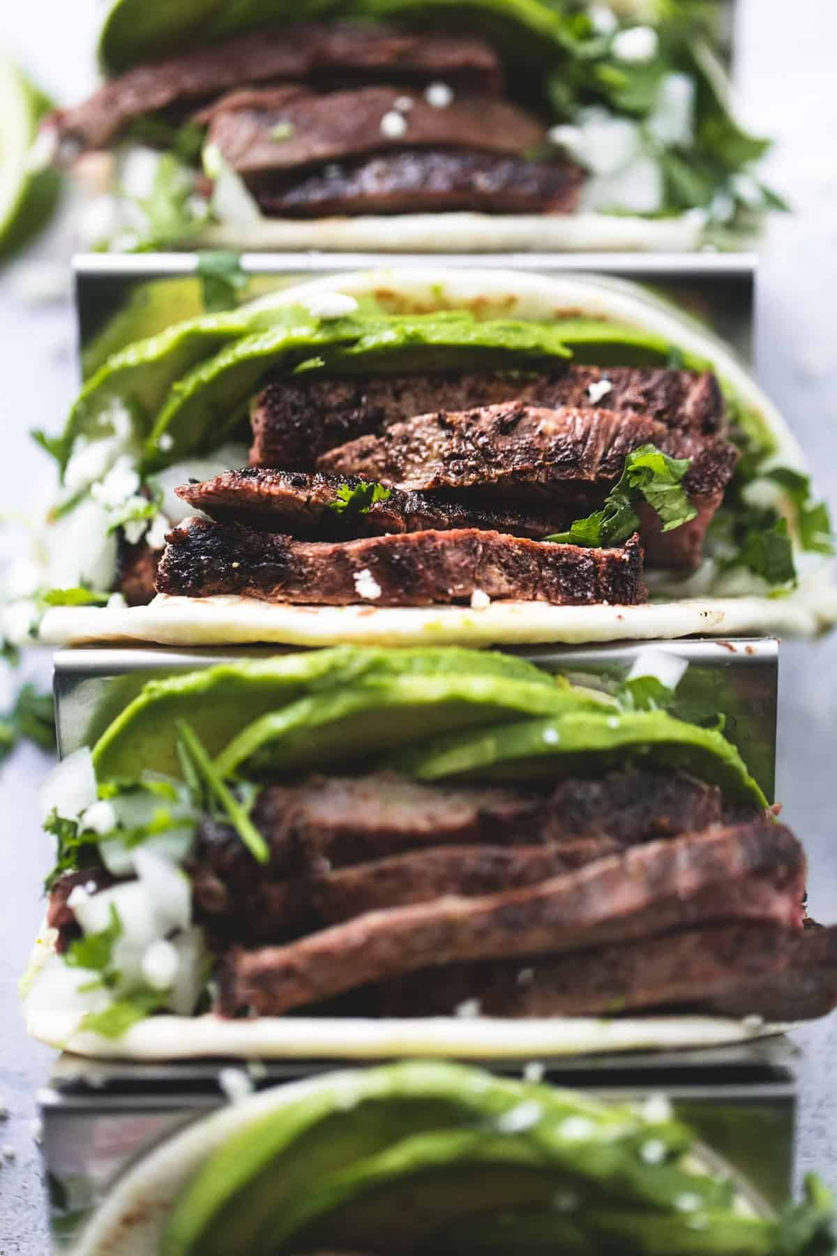 close up top view of flank steak tacos on a taco rack.