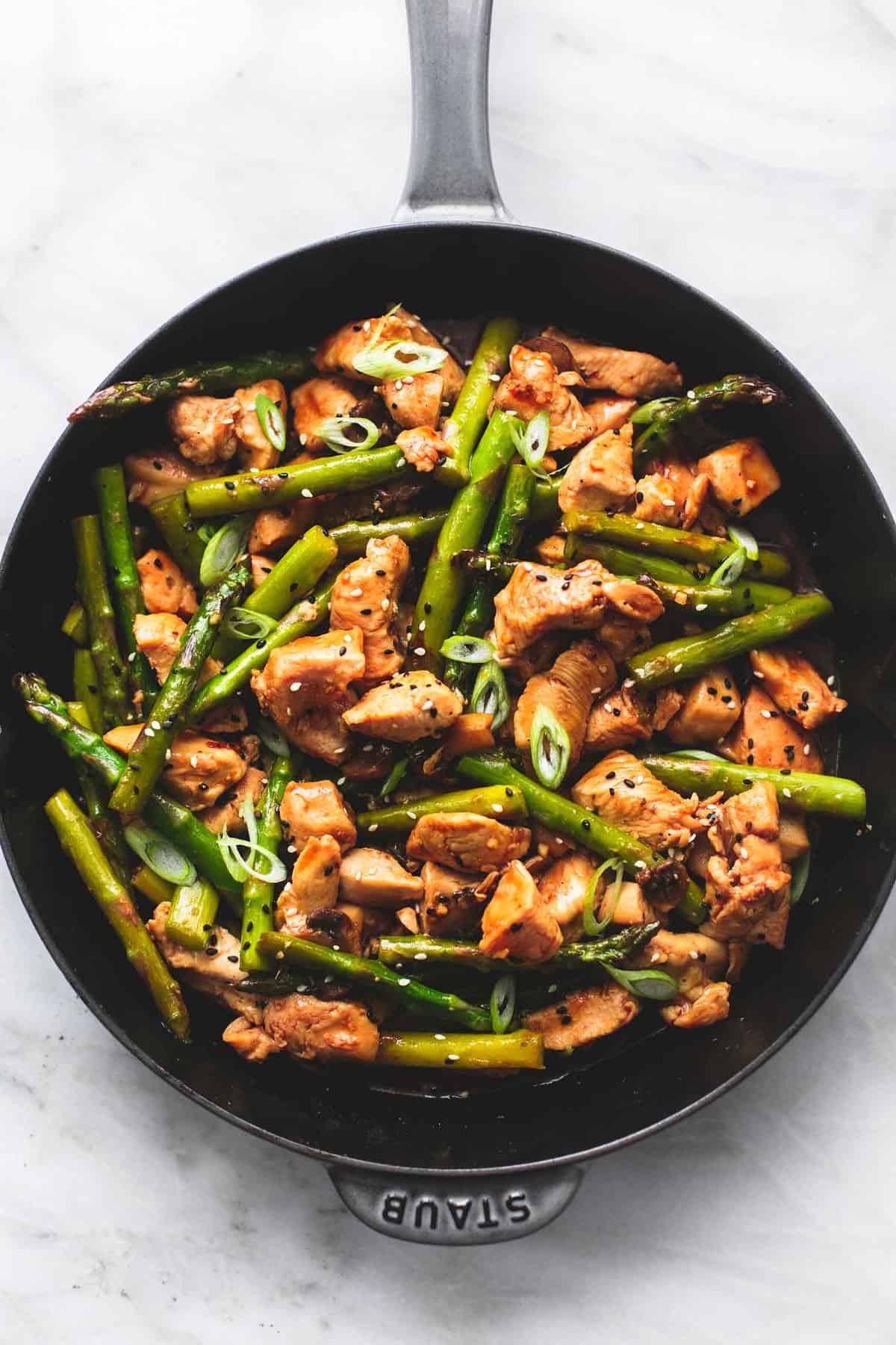 top view of chicken and asparagus stir fry in a pan.