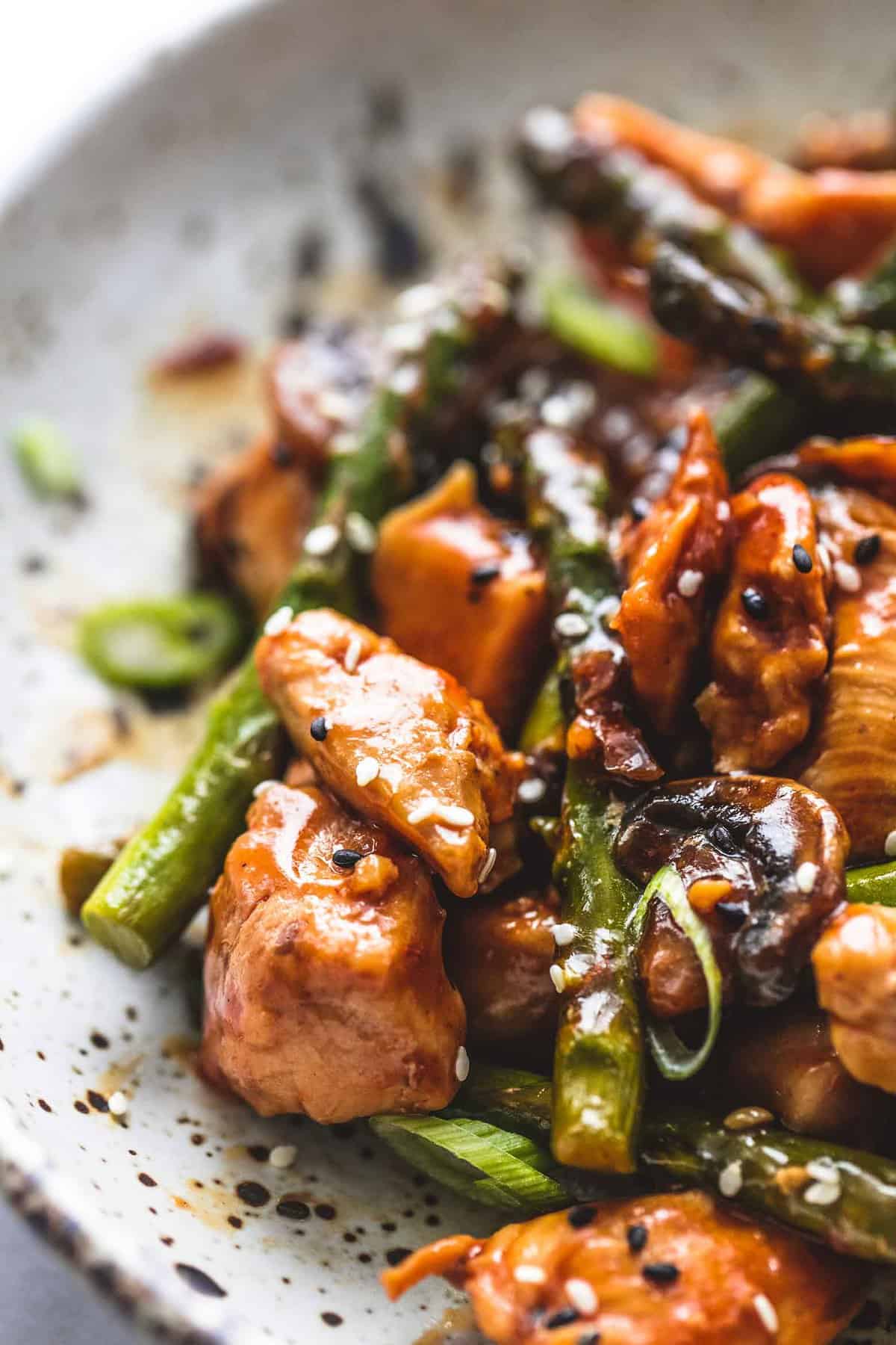 close up of chicken and asparagus stir fry on a plate.
