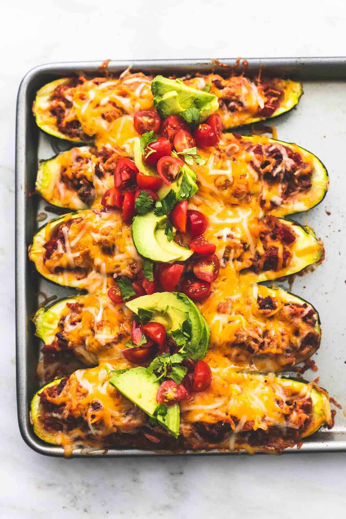 close up top view of taco stuffed zucchini boats on a baking sheet.