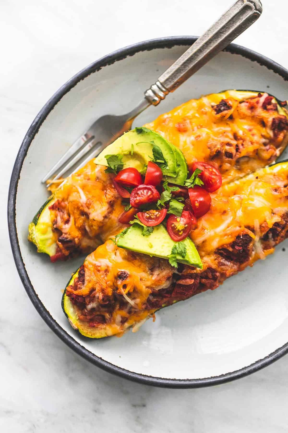 top view of taco stuffed zucchini boats with a fork on a plate.