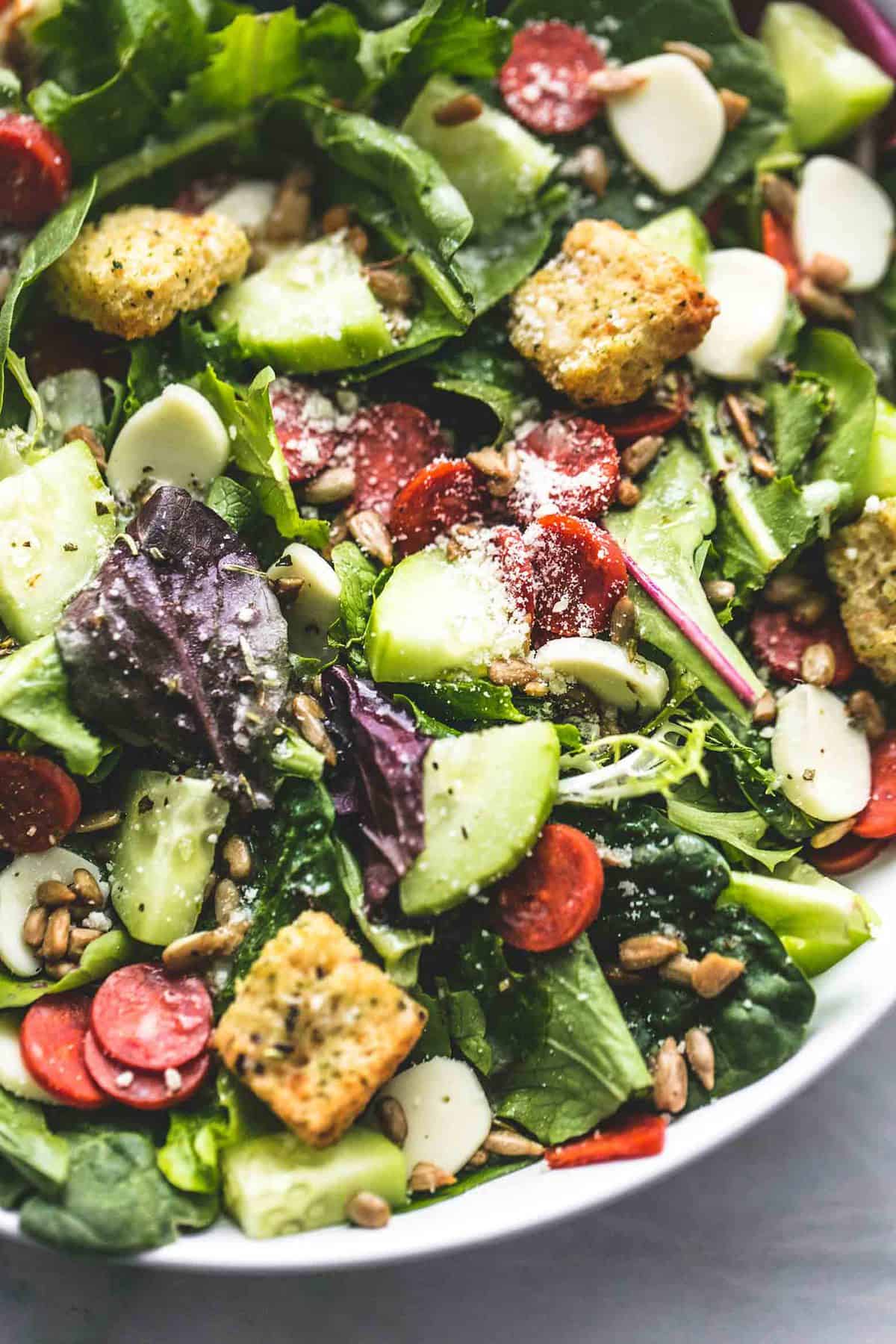 close up top view of Italian green salad in a bowl.