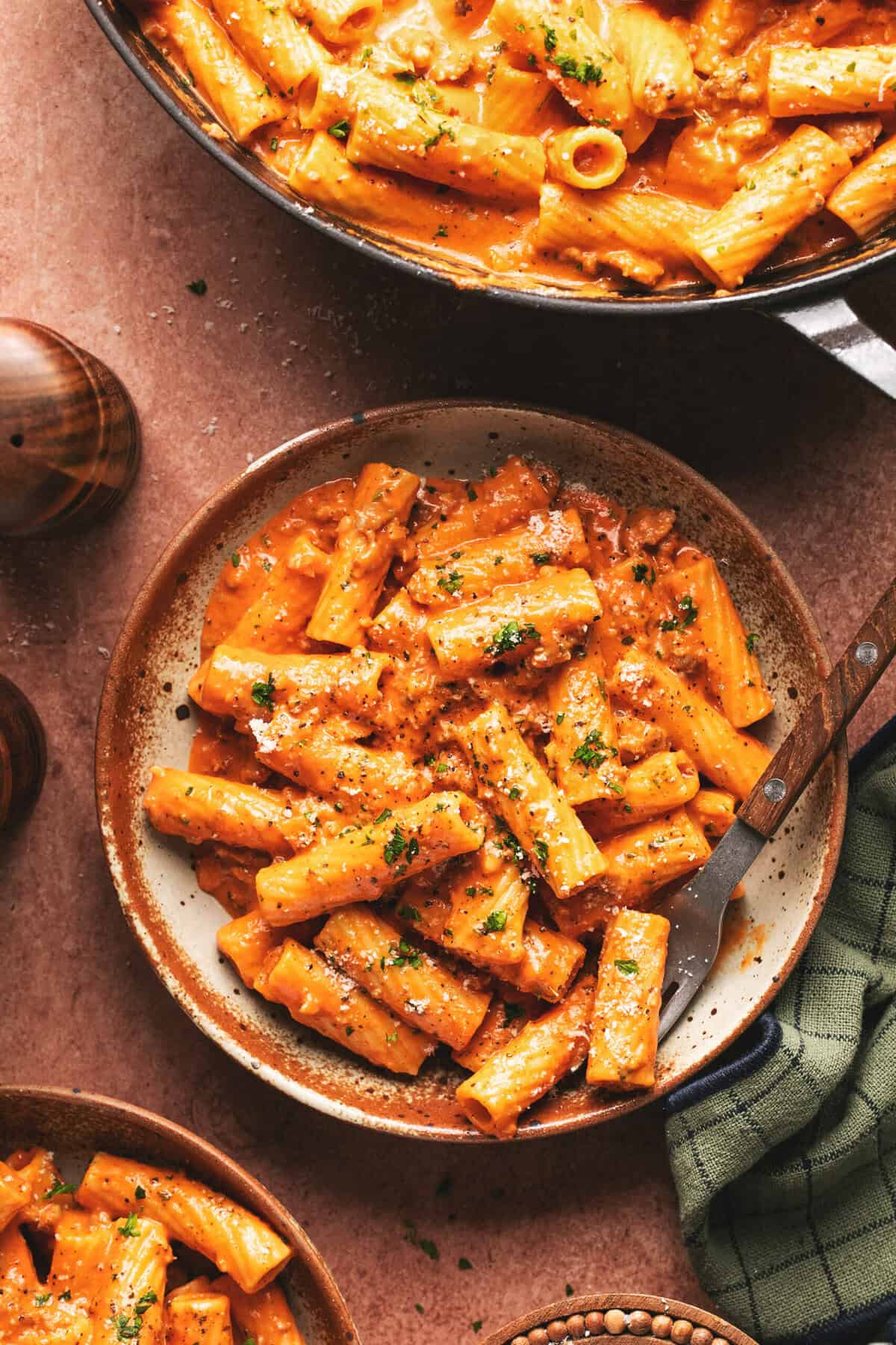 Overhead of pasta with creamy roasted red pepper sauce and a fork on a plate.