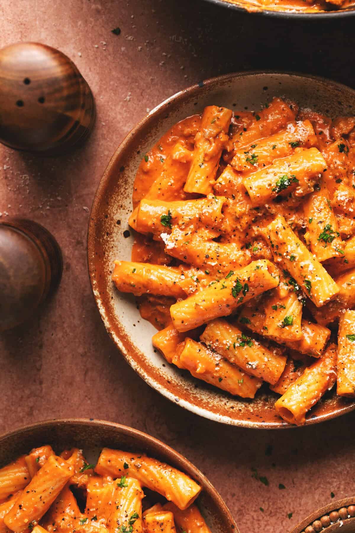 Overhead close up of pasta with creamy roasted red pepper sauce on a plate.