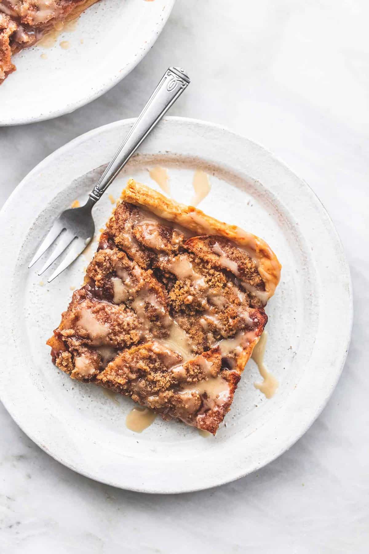 top view of a piece of apple slab pie with a fork on a plate.