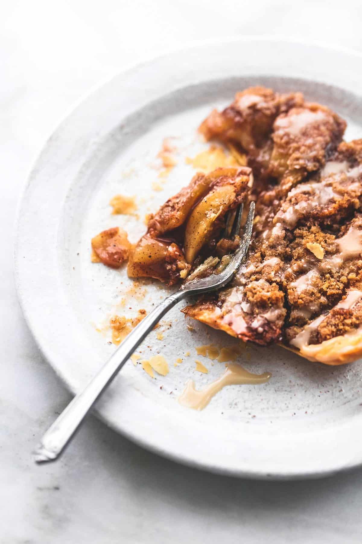 a piece of apple slab pie with a fork cutting into it on a plate.