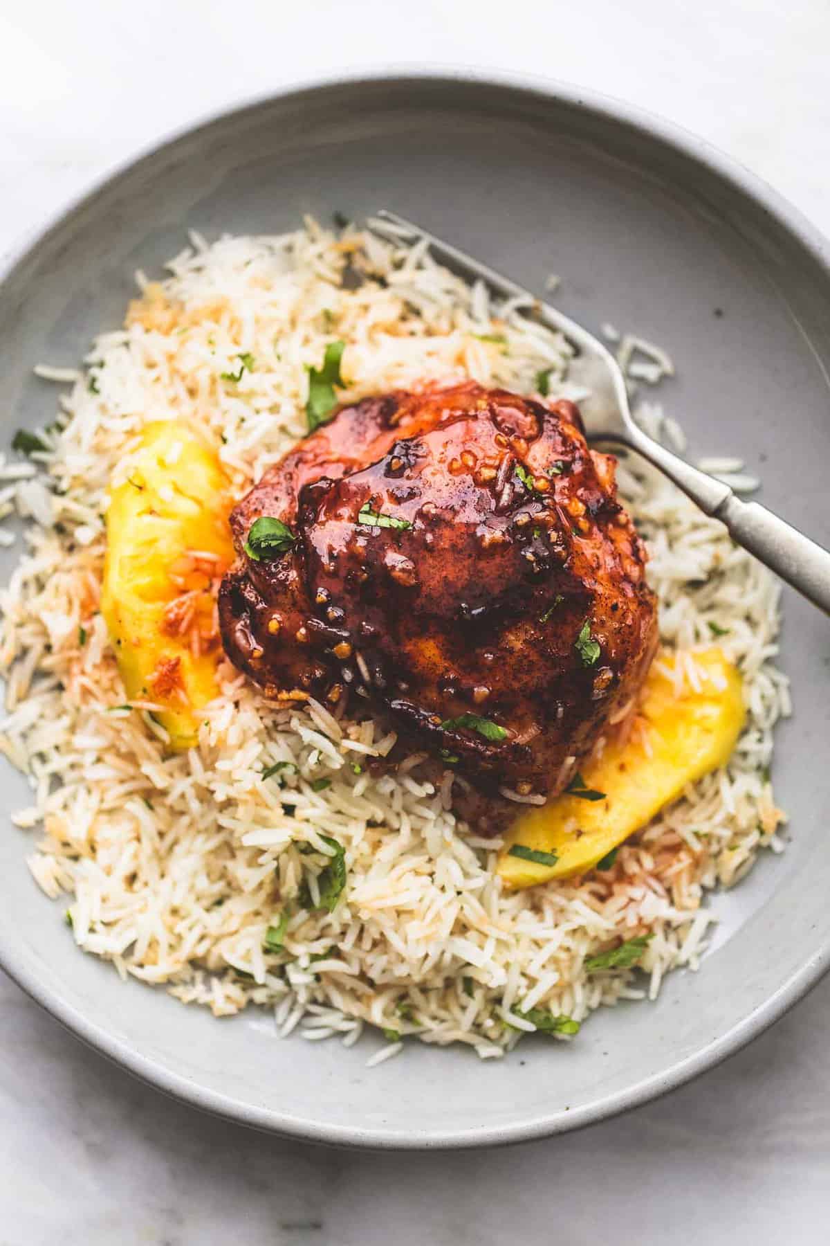 Island glazed chicken and coconut rice with a fork on a plate.