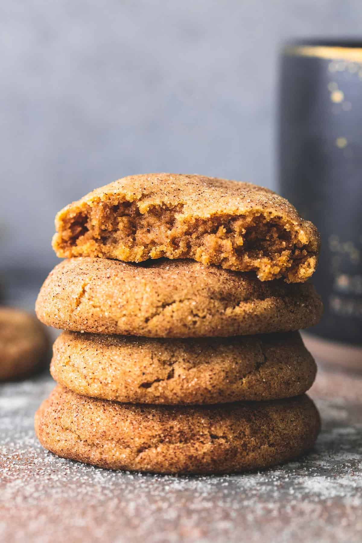 stacked pumpkin snickerdoodles with the top cookie missing a bite.