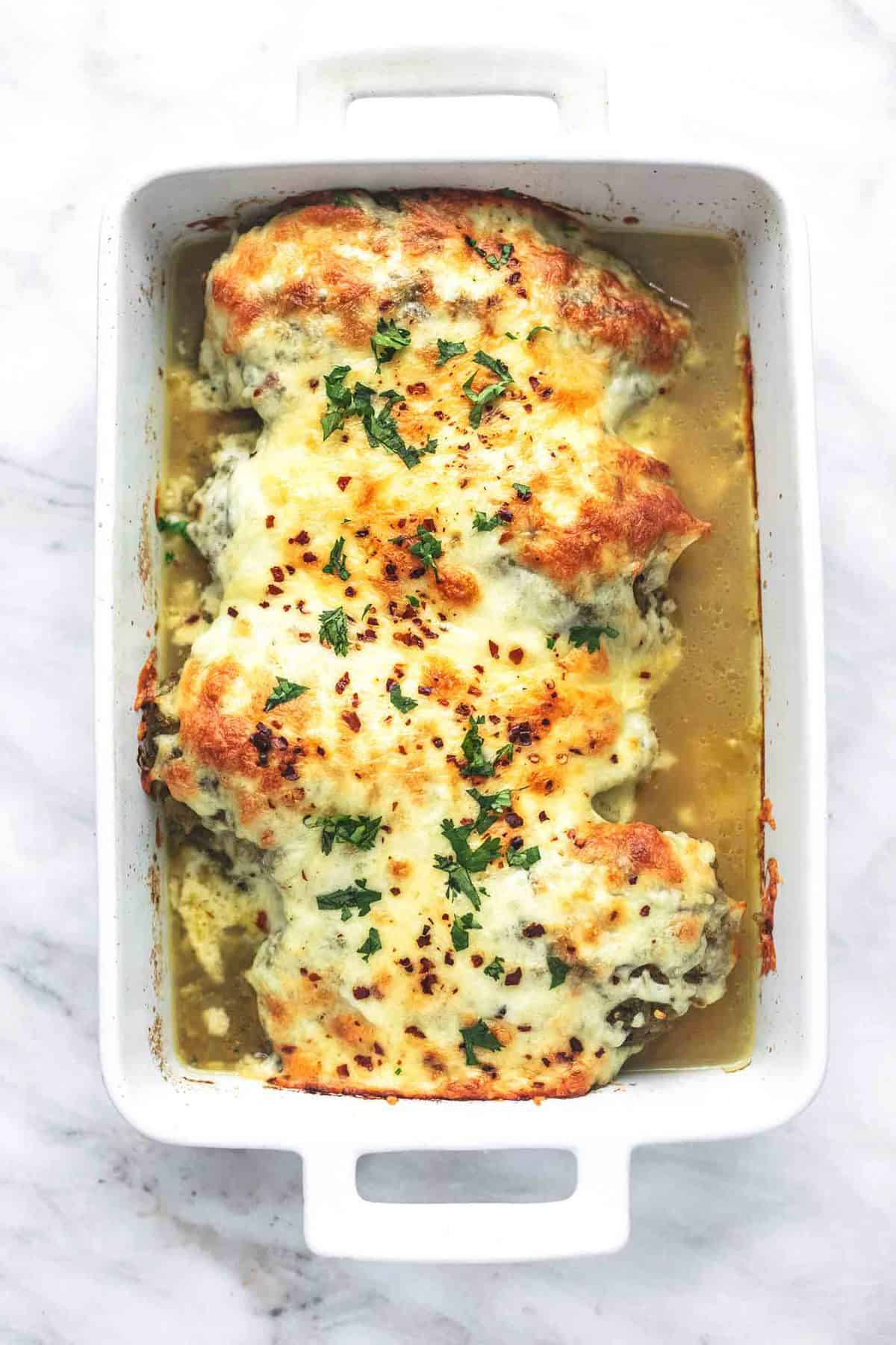 top view of baked salsa verde chicken in a baking pan.