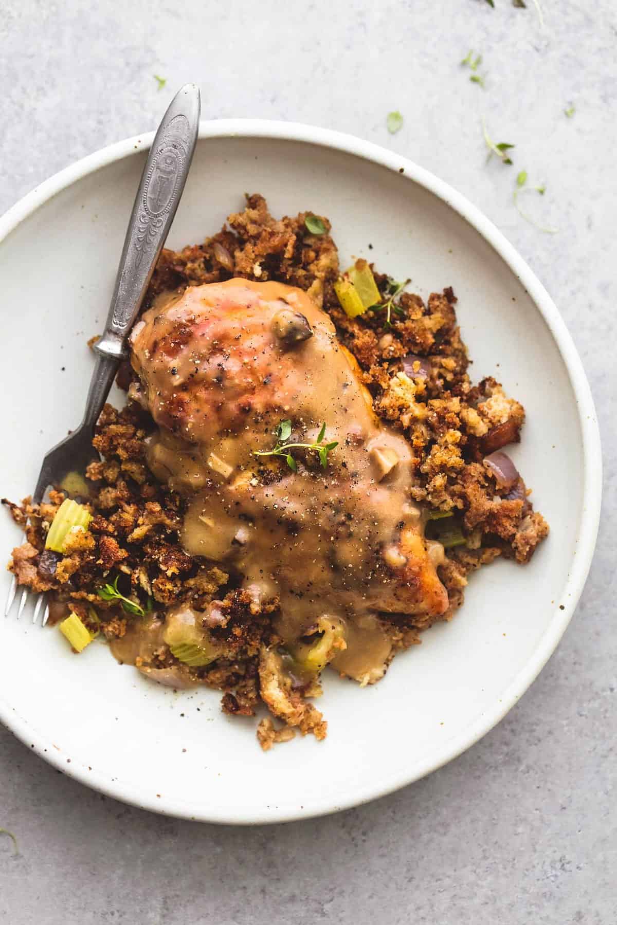 top view of skillet chicken and stuffing with a fork on a plate.