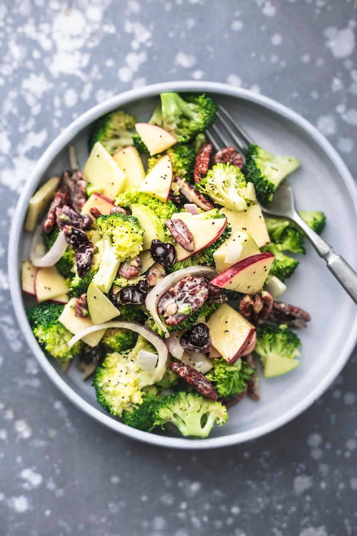 top view of broccoli apple salad with poppyseed dressing with a fork on a plate.