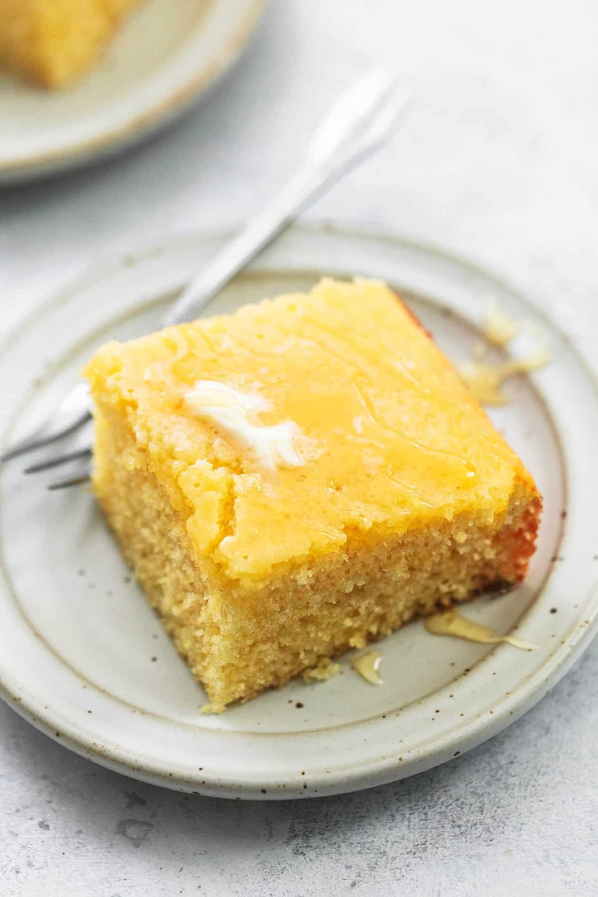 a piece of cornbread with a fork on a plate.