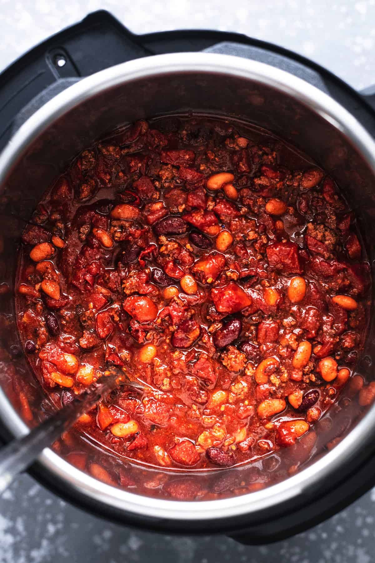 top view of chili with a serving spoon in an instant pot.