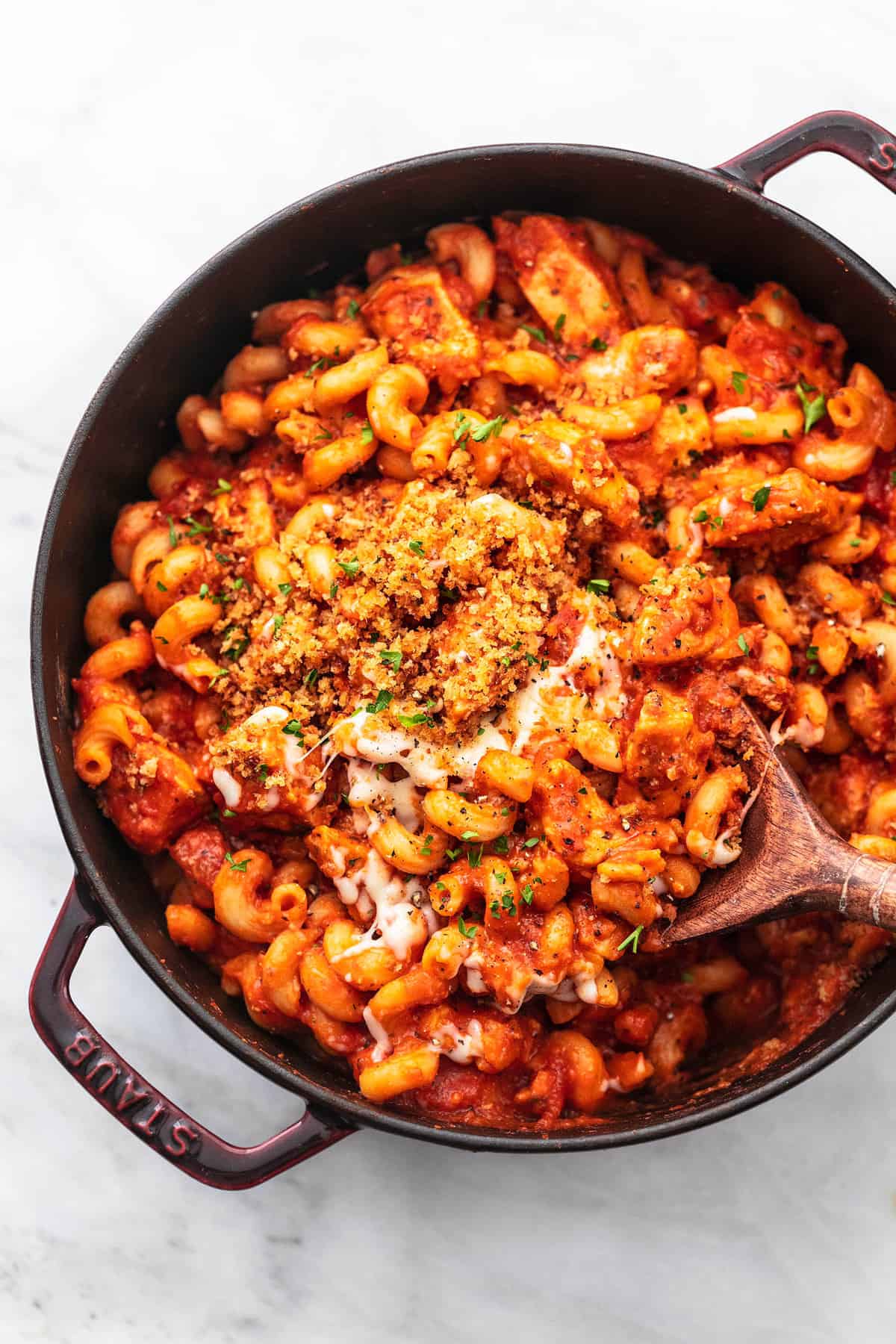 top view of chicken parmesan pasta with a serving spoon in a pan.