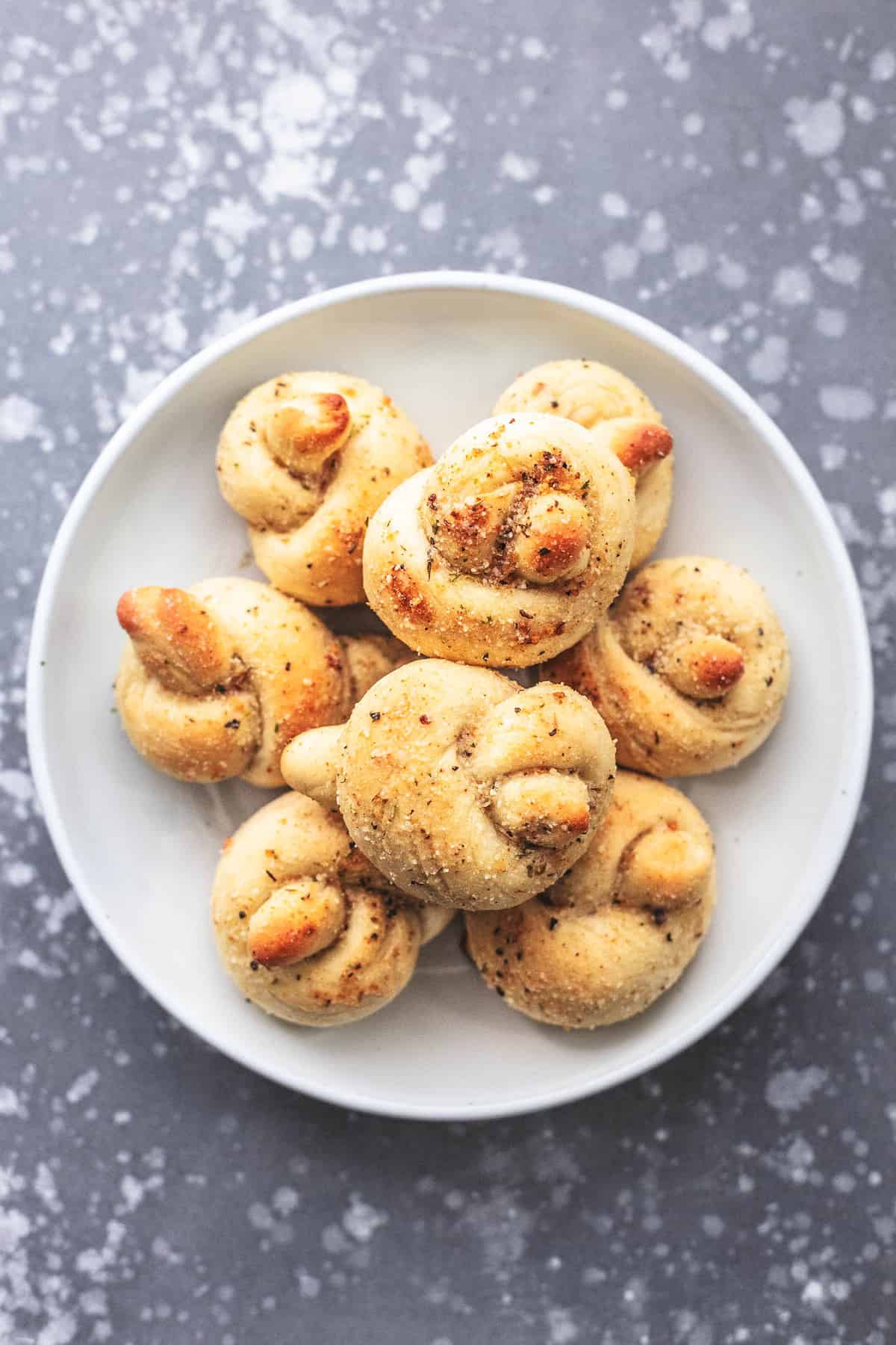 top view of homemade garlic parmesan knots on a plate.