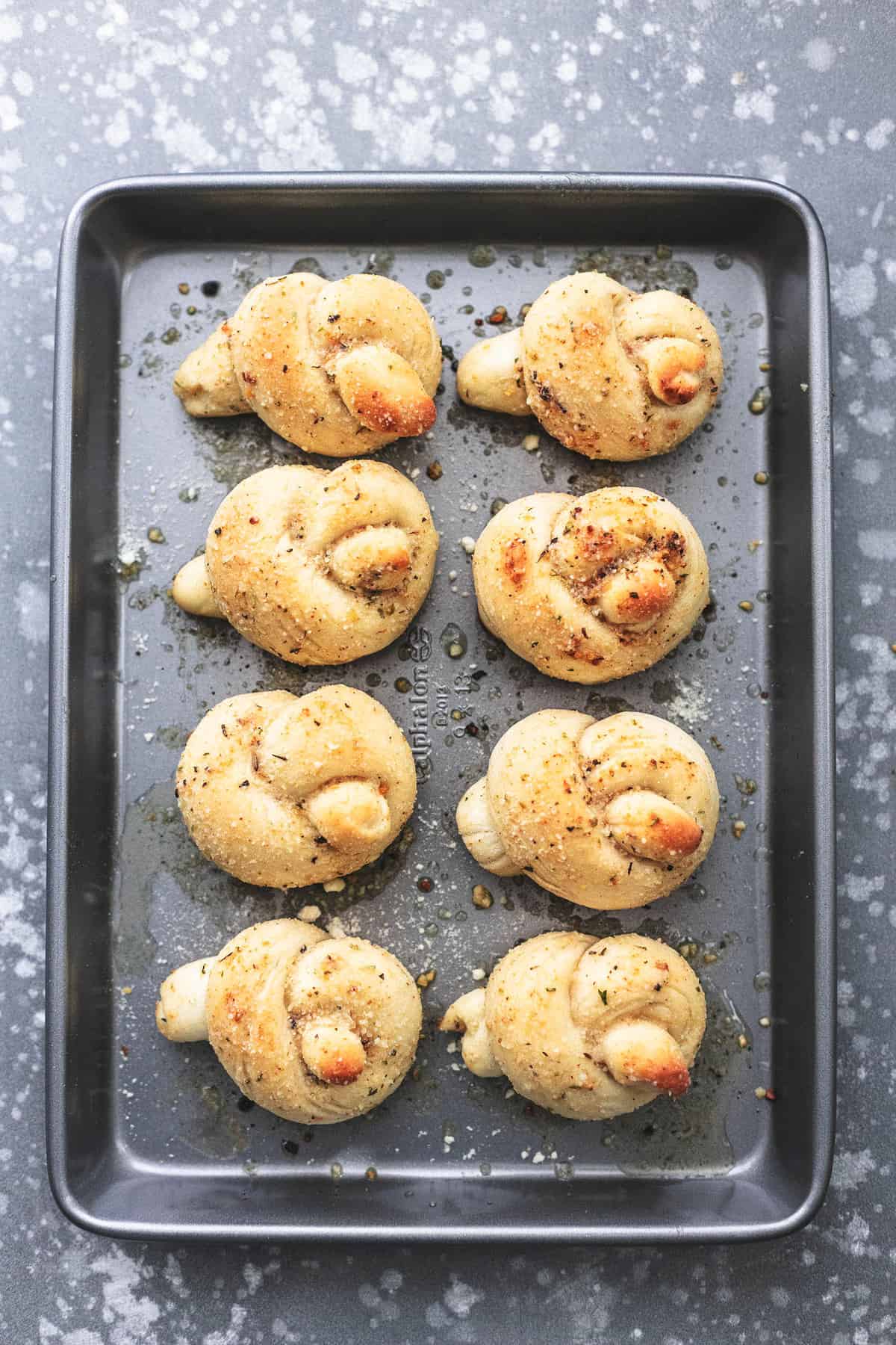 top view of homemade garlic parmesan knots on a baking sheet.