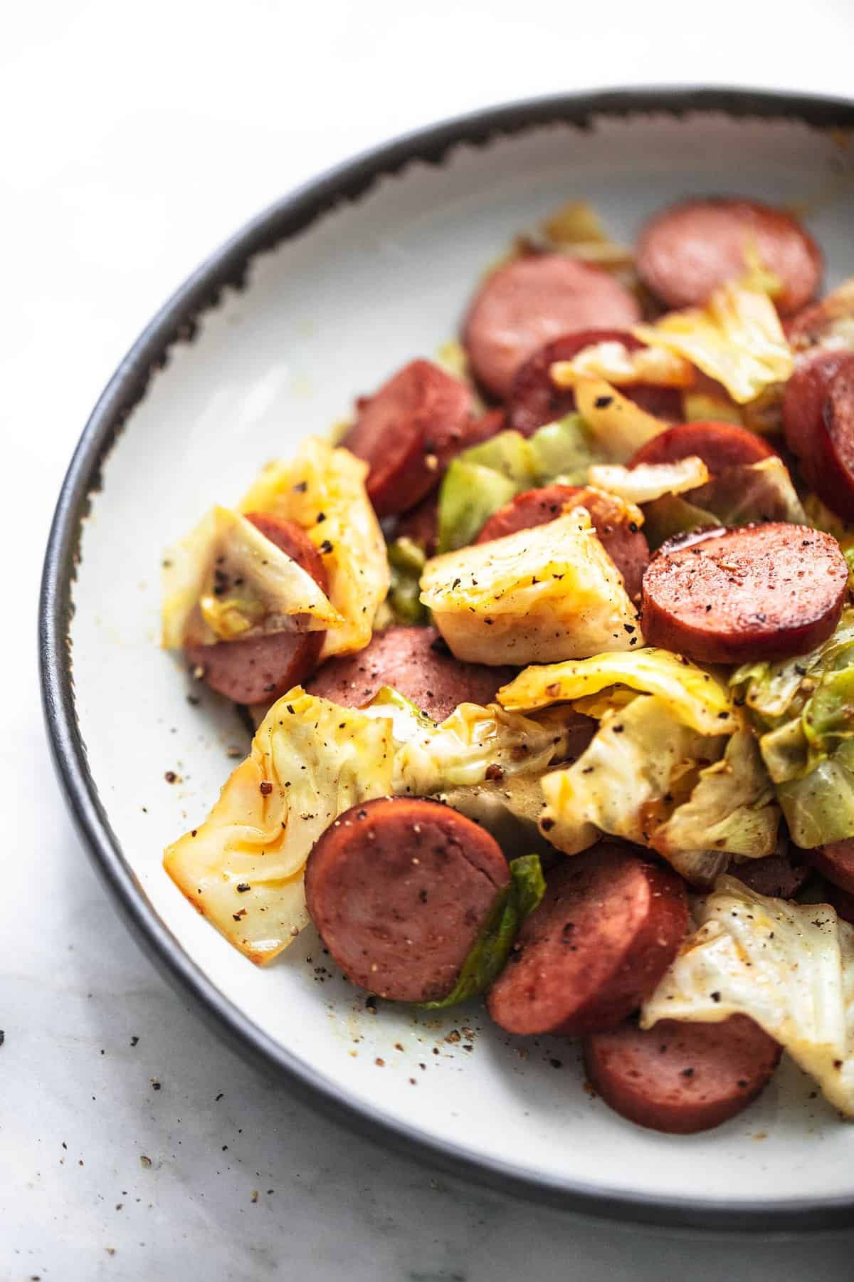 close up of sausage and cabbage skillet on a plate.