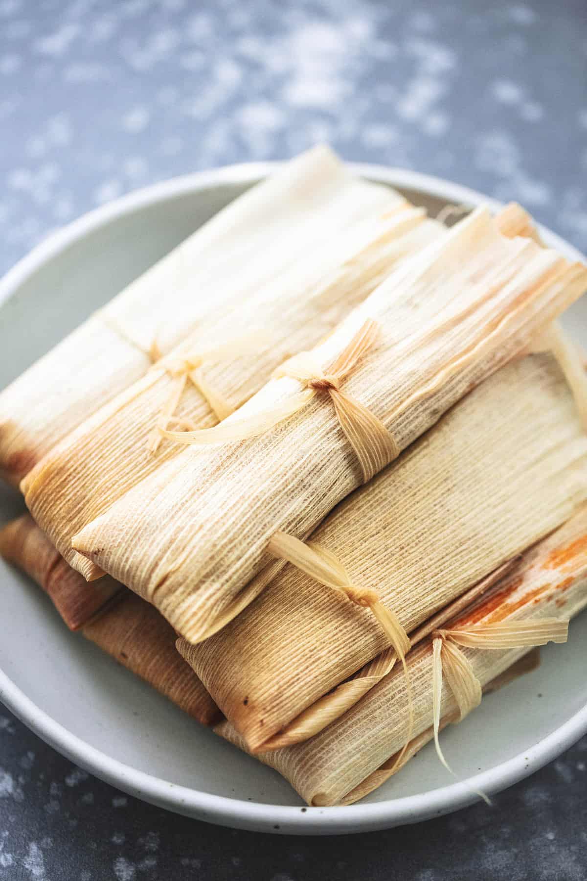 wrapped tamales on a plate.