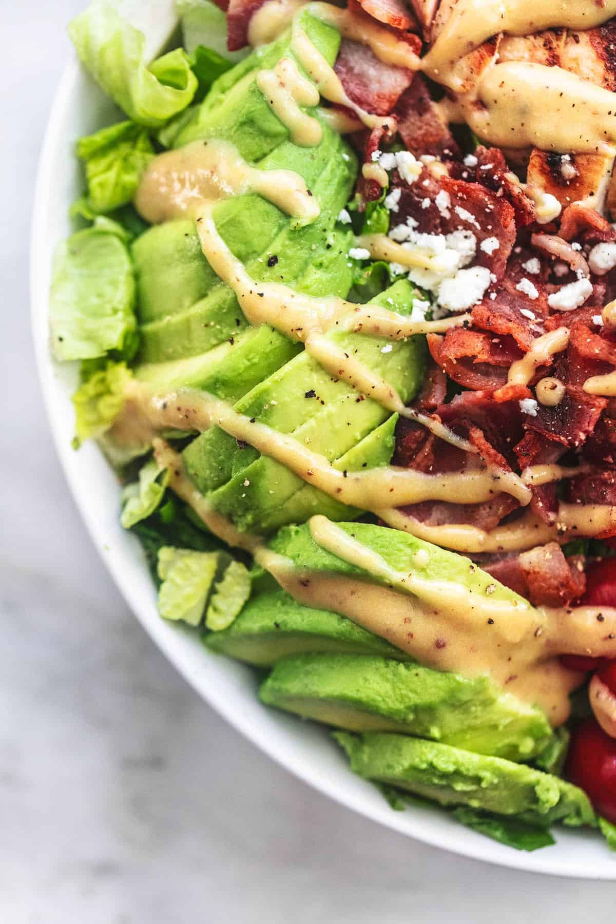 close up top view of chicken avocado salad with fat free Dijon salad dressing on top.