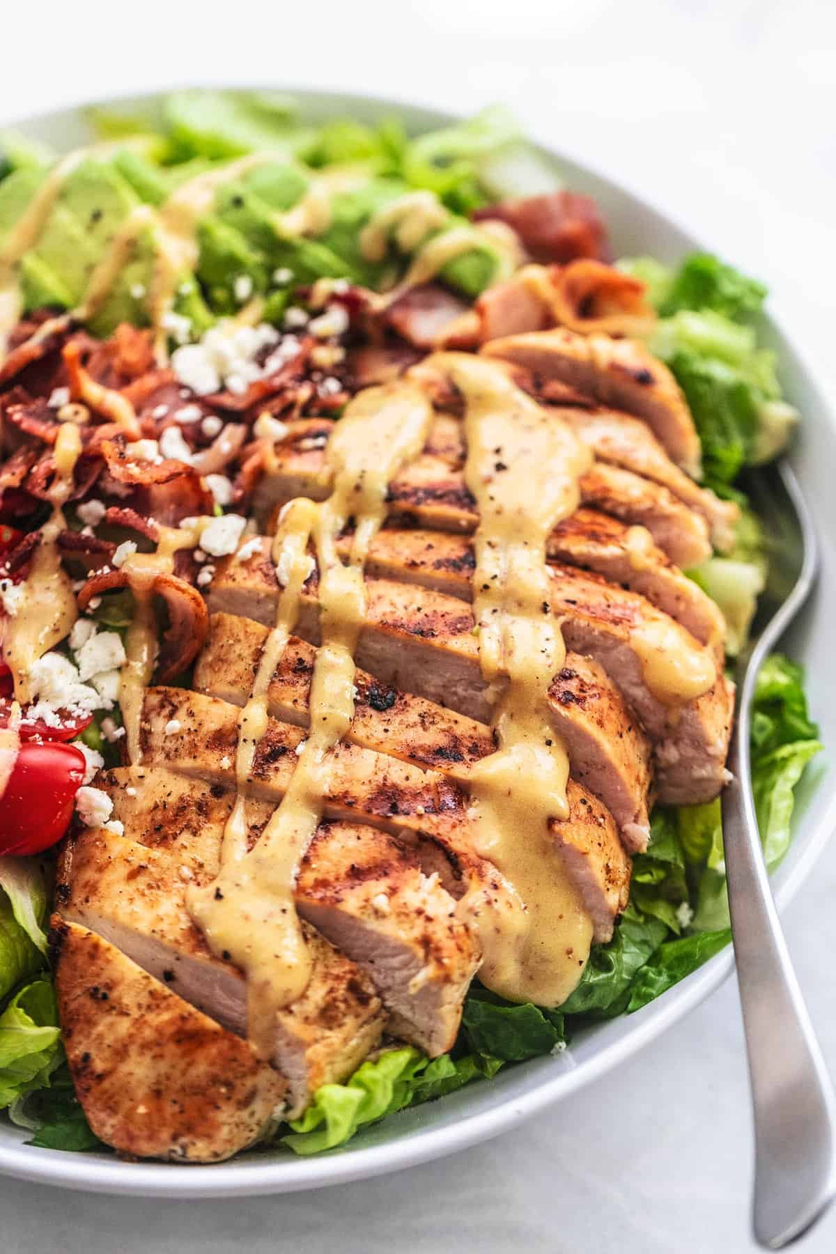 close up of chicken avocado salad with a fork on a plate.