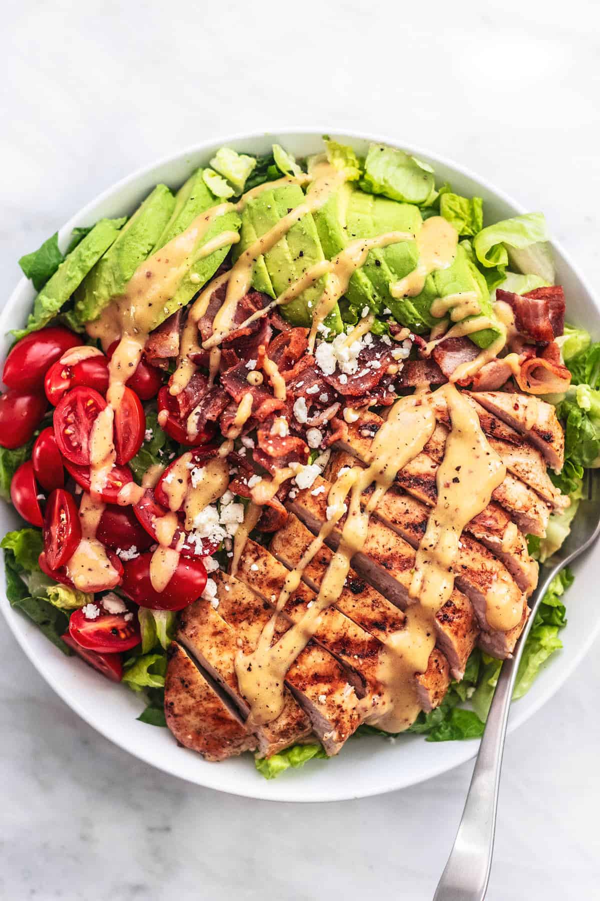 top view of chicken avocado salad with a fork on a plate.