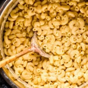 Overhead of instant pot mac and cheese with a wooden spoon in an instant pot.