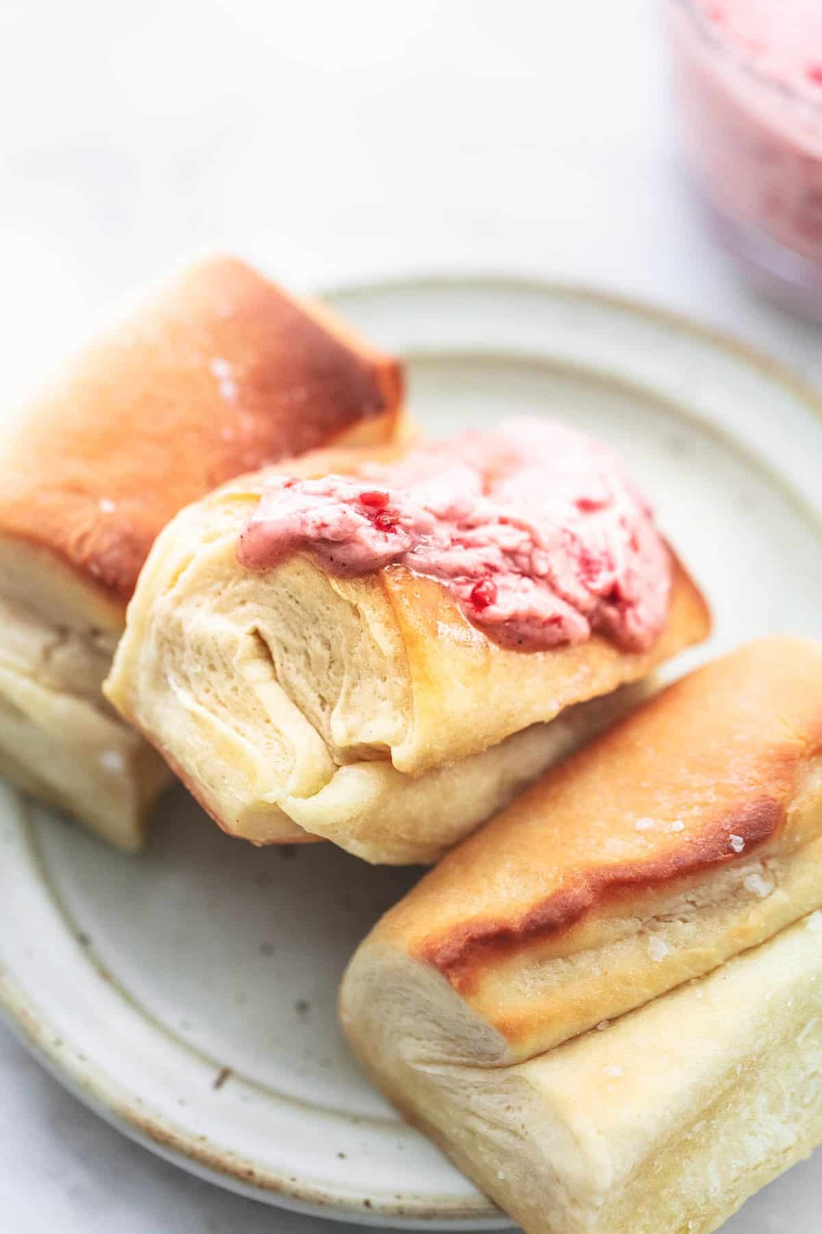 homemade Parker House rolls with raspberry almond butter on a plate.