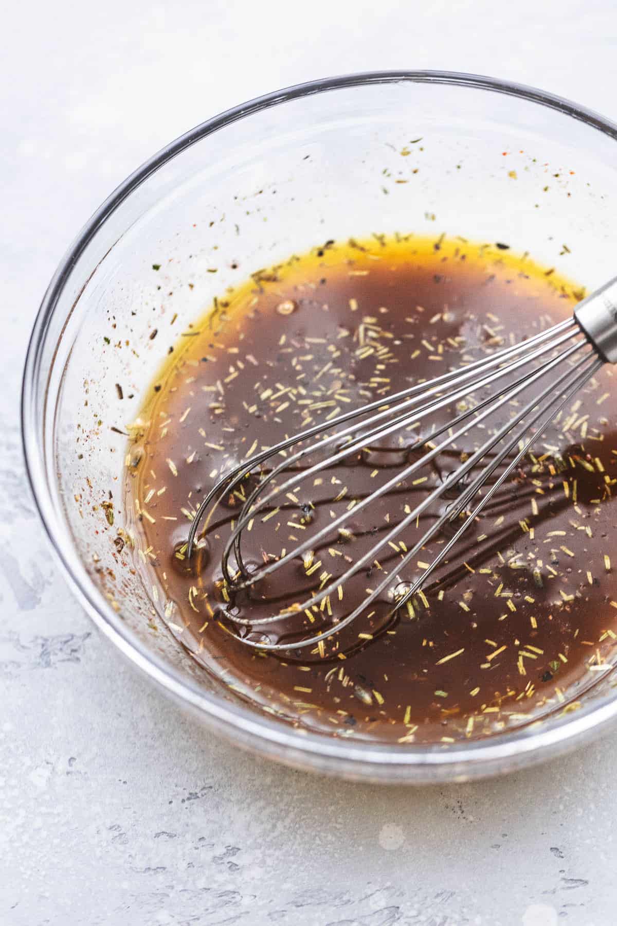 pork marinade with a whisk in a glass bowl.