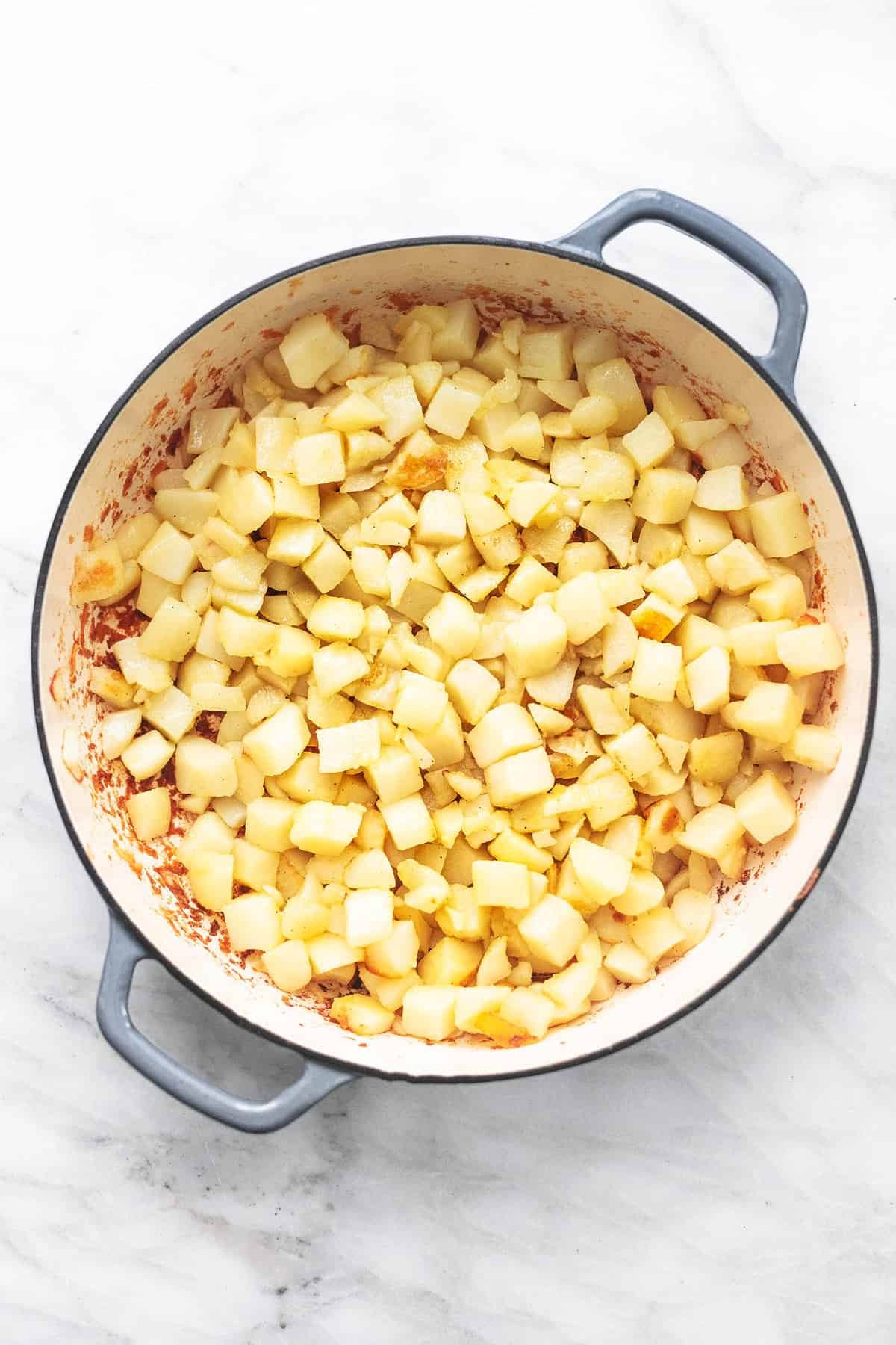 top view of raw potatoes cut up into small cubes in a pan.