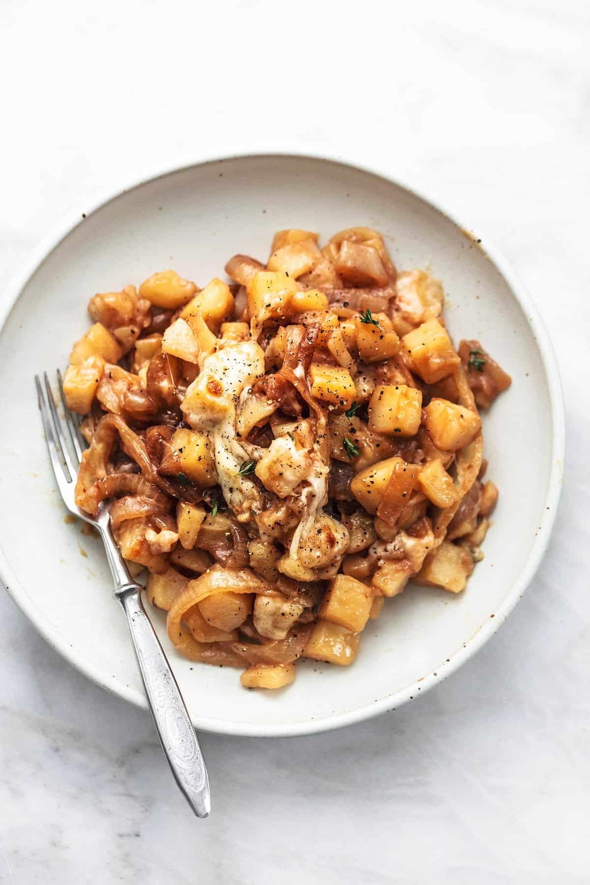 top view of French onion potatoes with a fork on a plate.