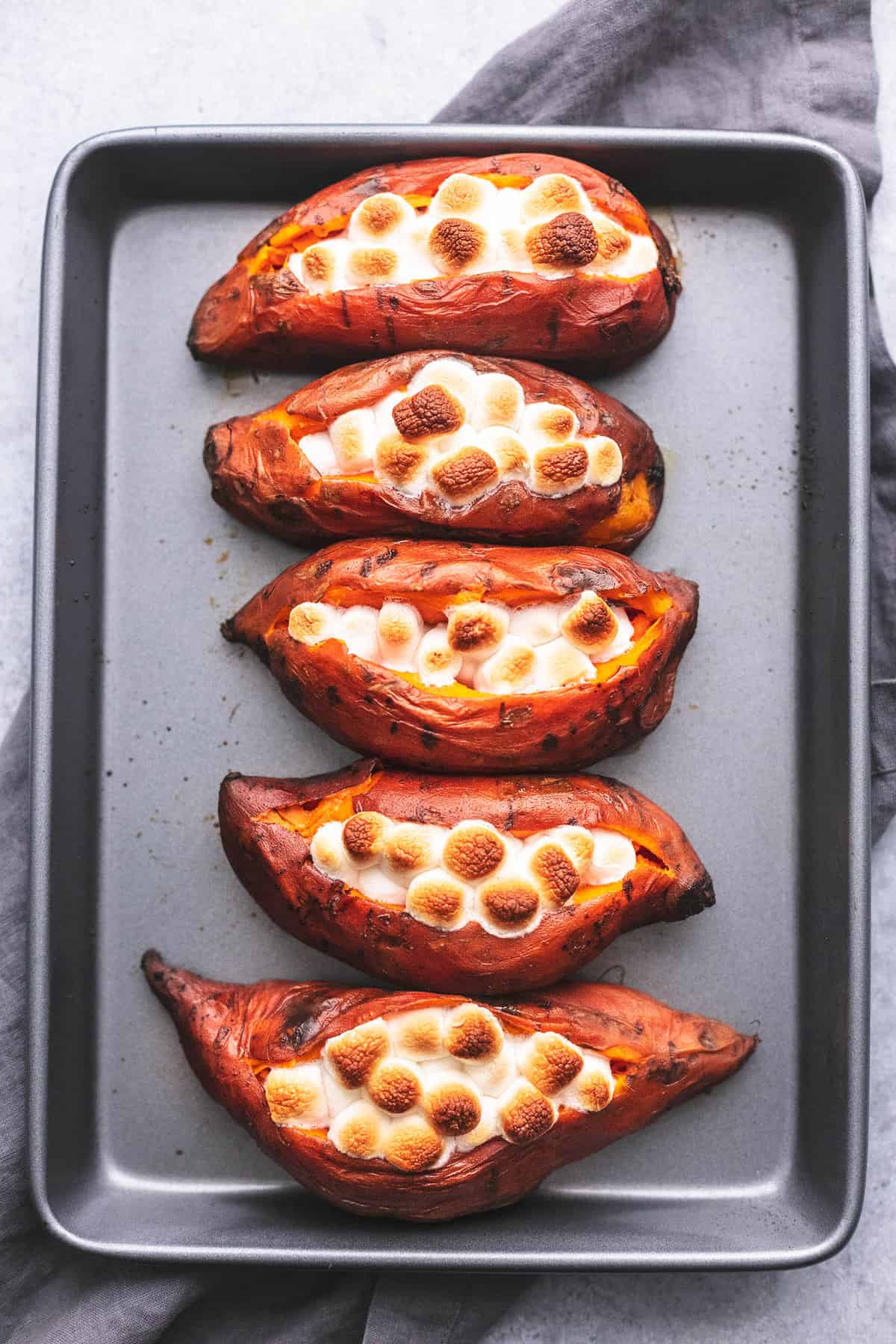 top view of instant pot baked sweet potatoes topped with marshmallows on a baking sheet.