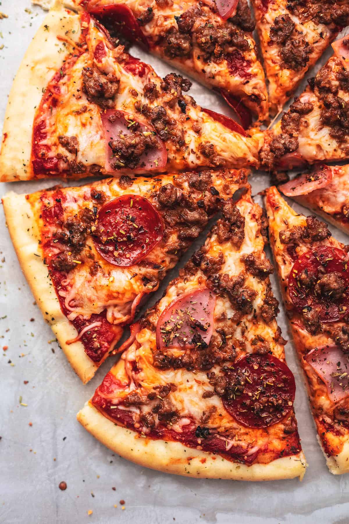 close up top view of meat lovers pizza cut up in slices.